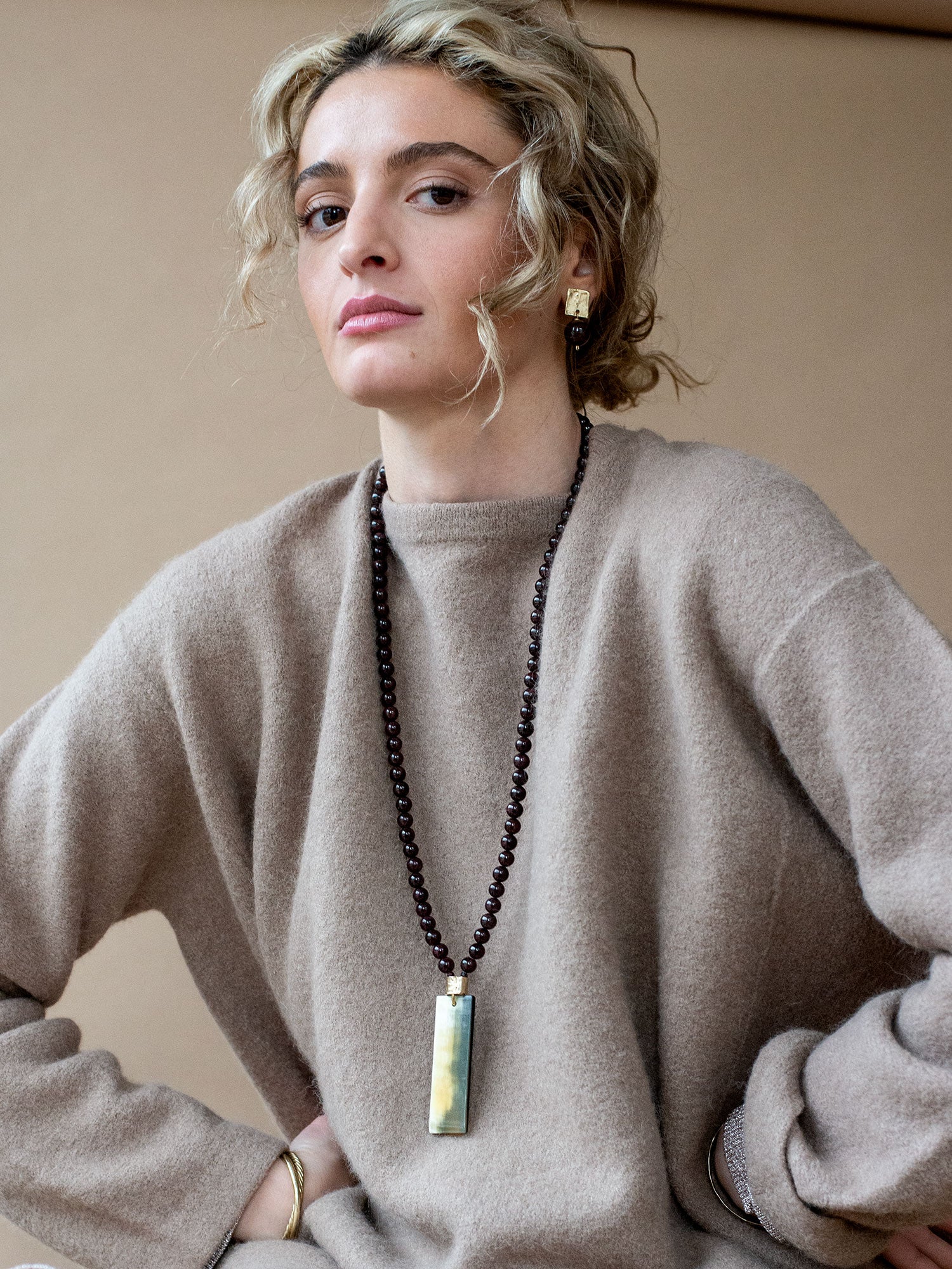 Pair of earrings with brass square tops and garnet beads by Michelle Ross