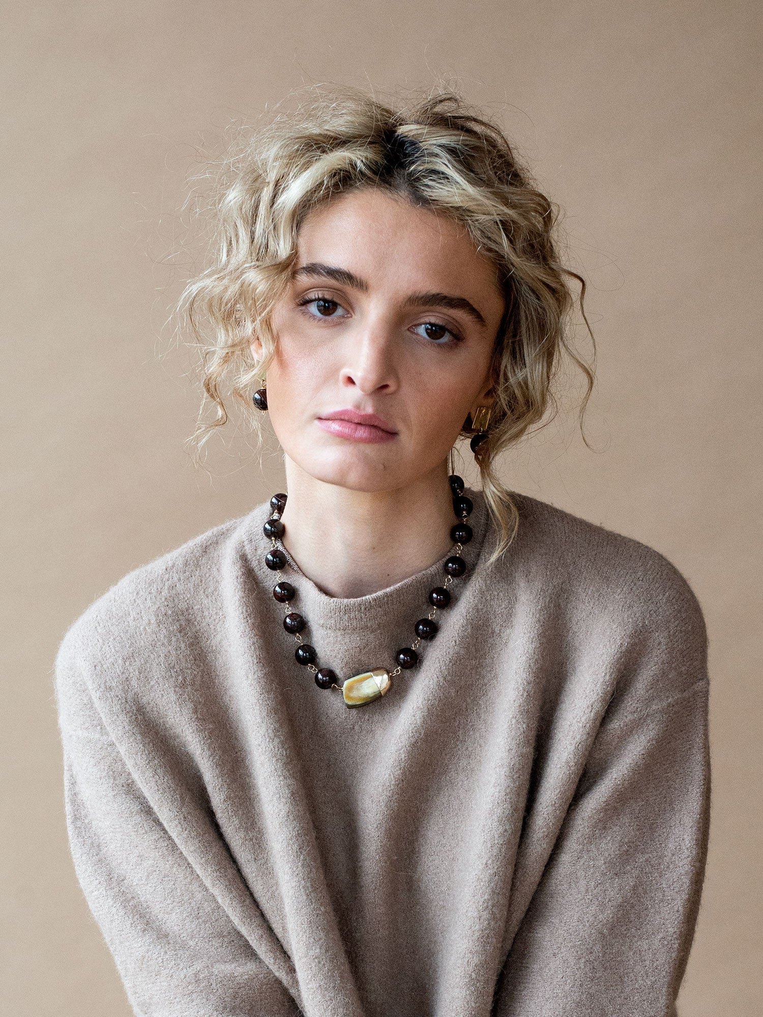 Beaded garnet collar necklace with a large horn pendant and brass details by Michelle Ross
