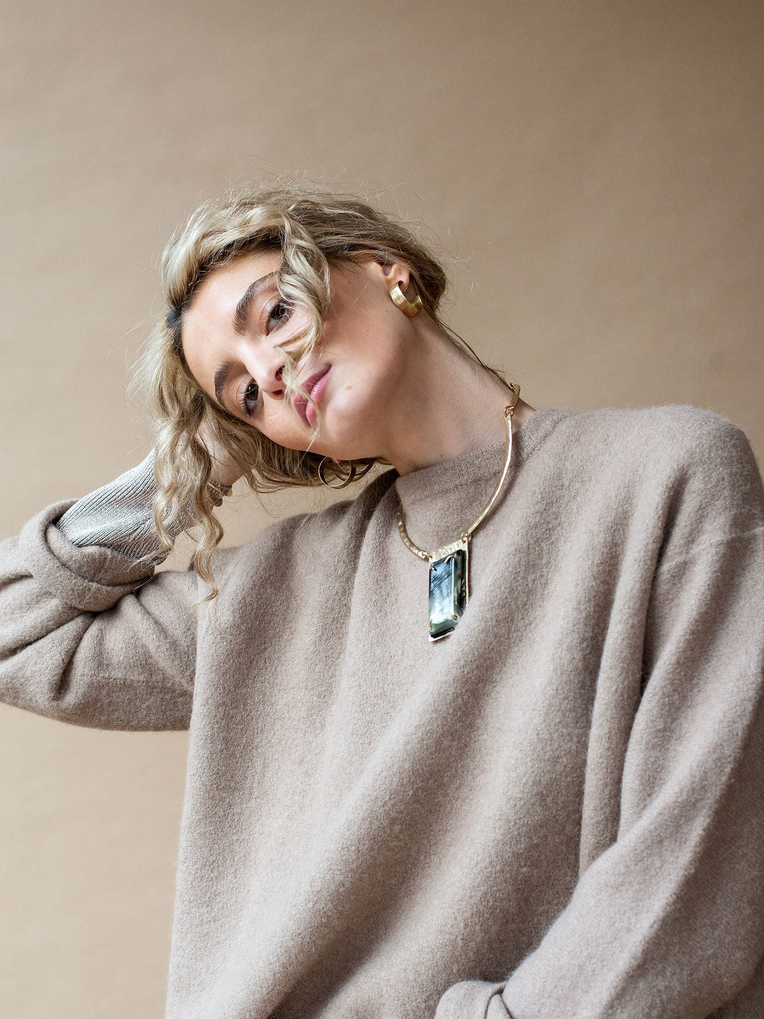 A solid brass collar necklace featuring a statement black horn pendant  by Michelle Ross