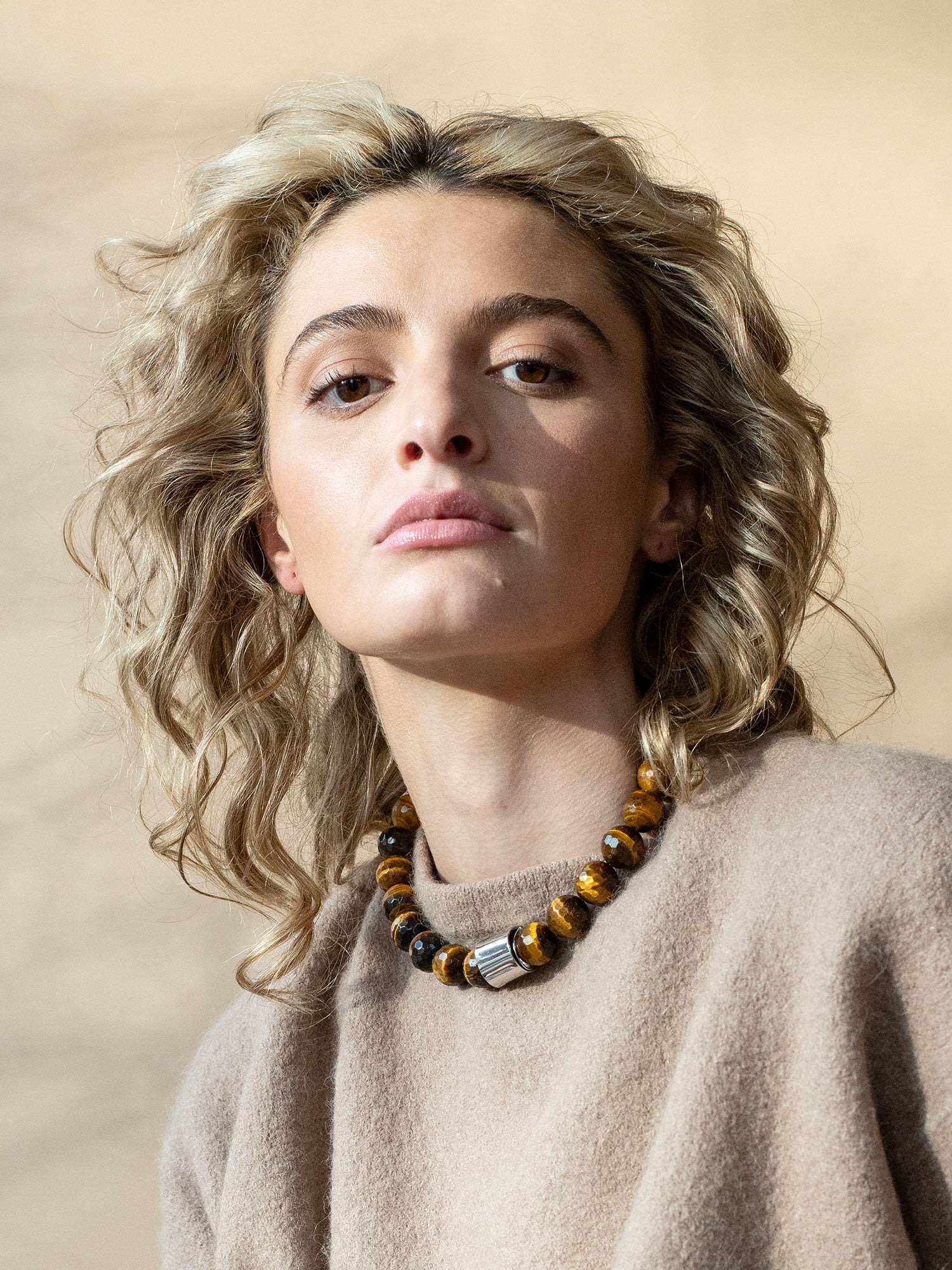 A beaded necklace with tiger eye beads and silver and brass details by Michelle Ross