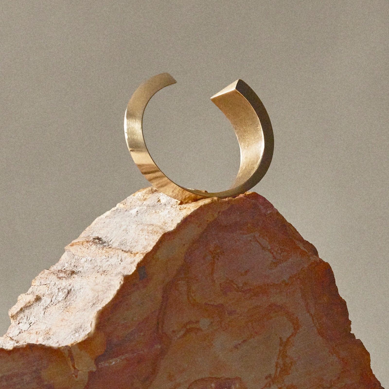 A large brass bangle sits on a sculpture by Canadian Jewelry Designer Michelle Ross