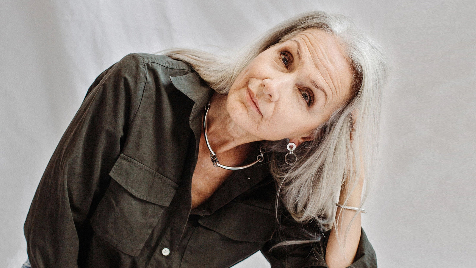 Woman with gray hairwearing sterling silver necklace, earrings, rings and bracelets by Canadian designer Michelle Ross