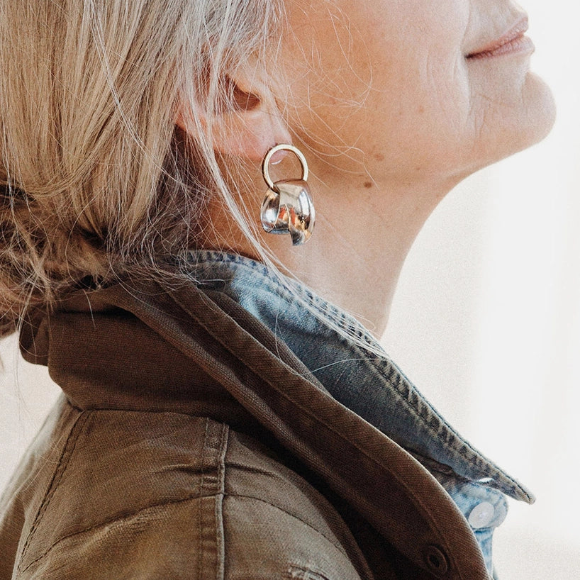 A woman wears sterling silver earrings from Canadian jewelry brand Michelle Ross