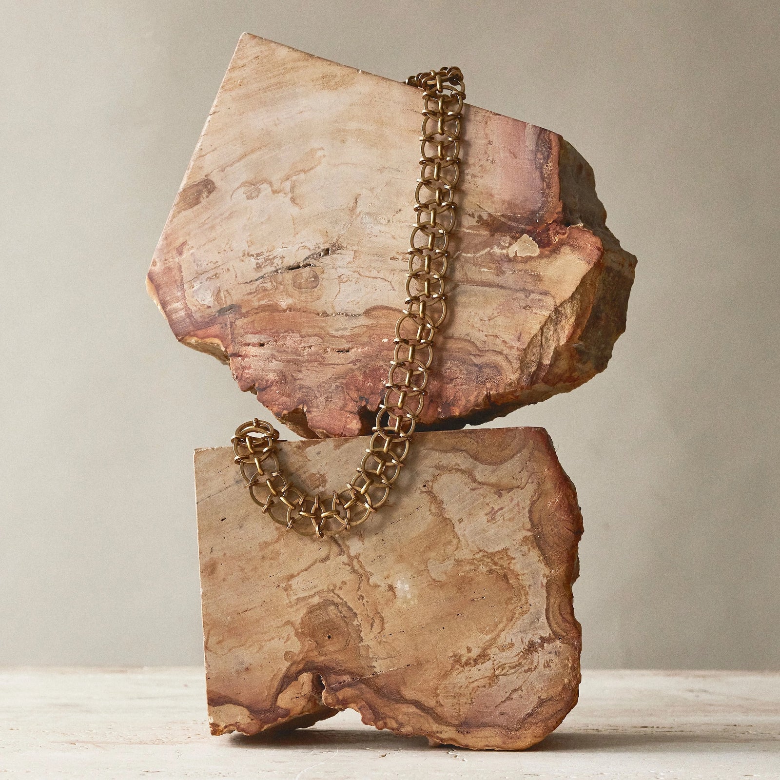 Chain link brass necklaces sit on a sculpture from Canadian jewelry brand Michelle Ross