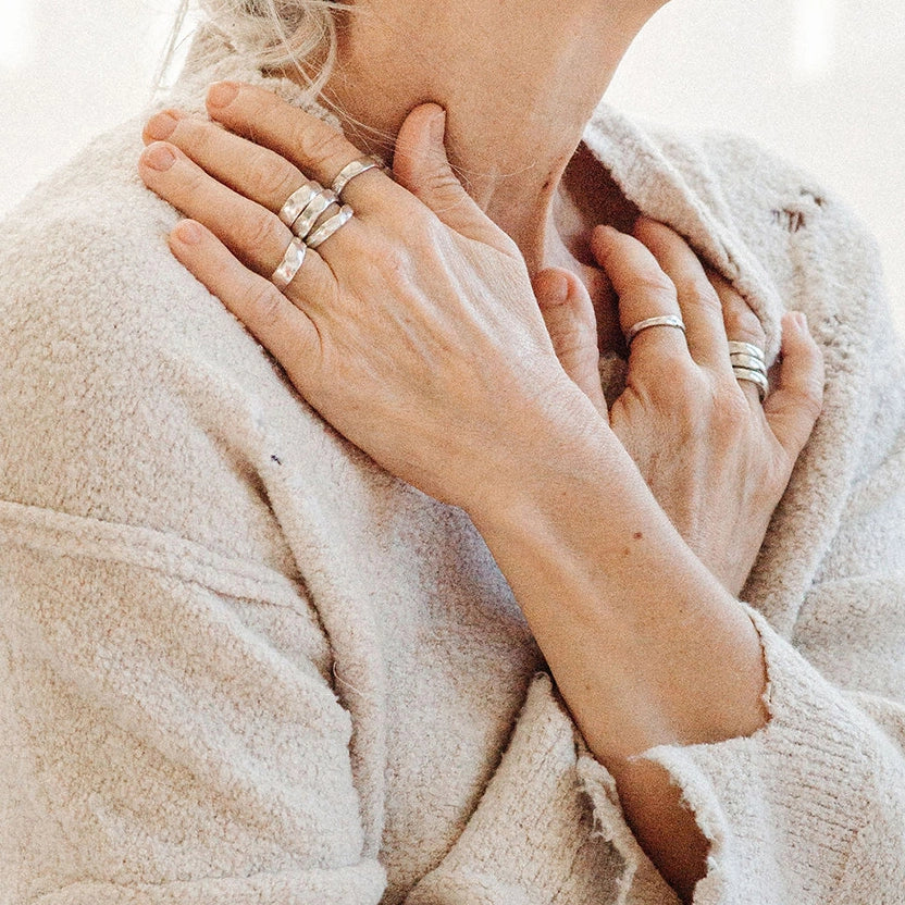 Close-up of a person wearing multiple silver rings by Canadian Jewelry Designer Michelle Ross
