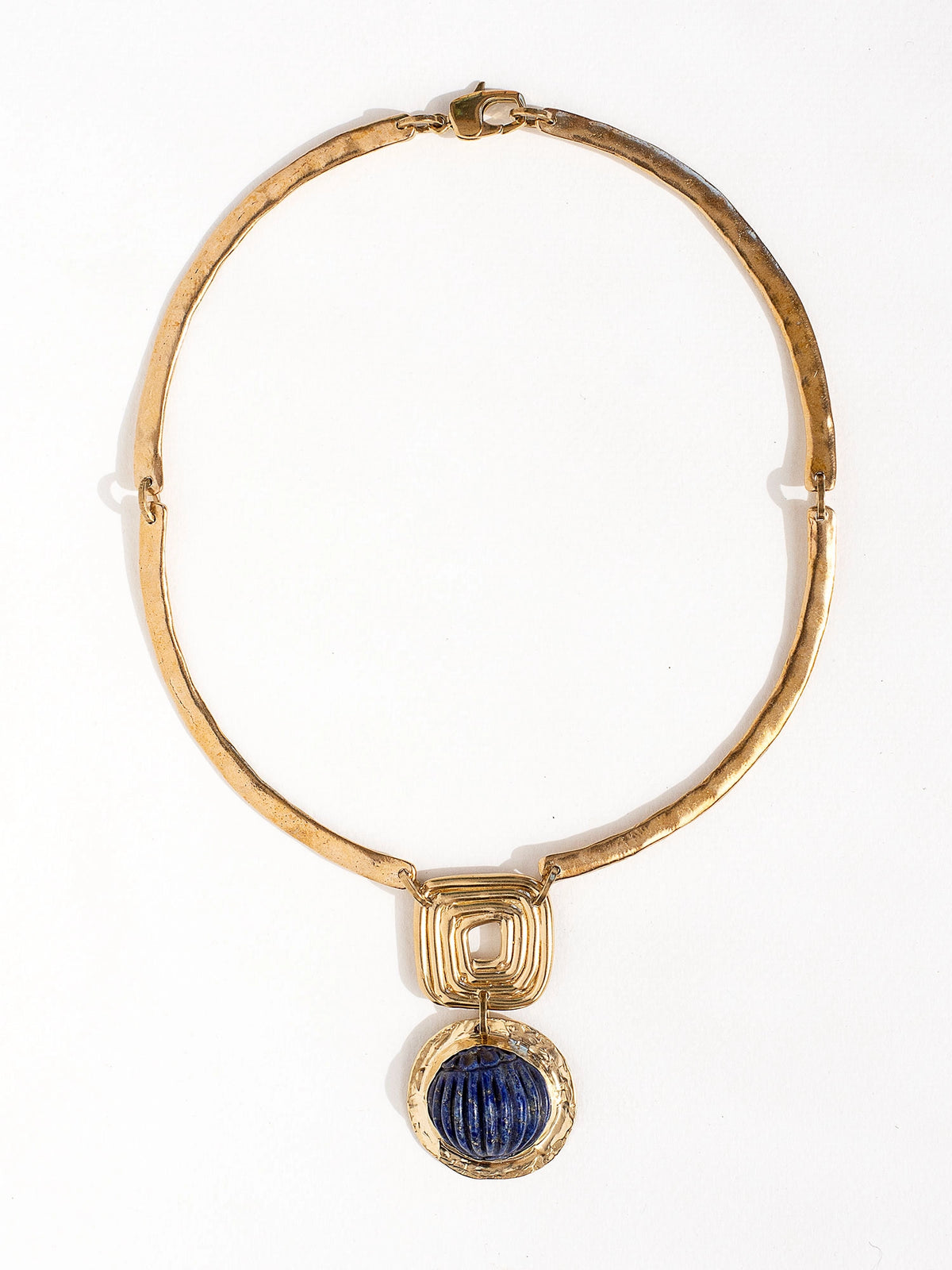 A solid brass collar necklace with a statement lapis lazuli pendant by Canadian jewelry designer Michelle Ross
