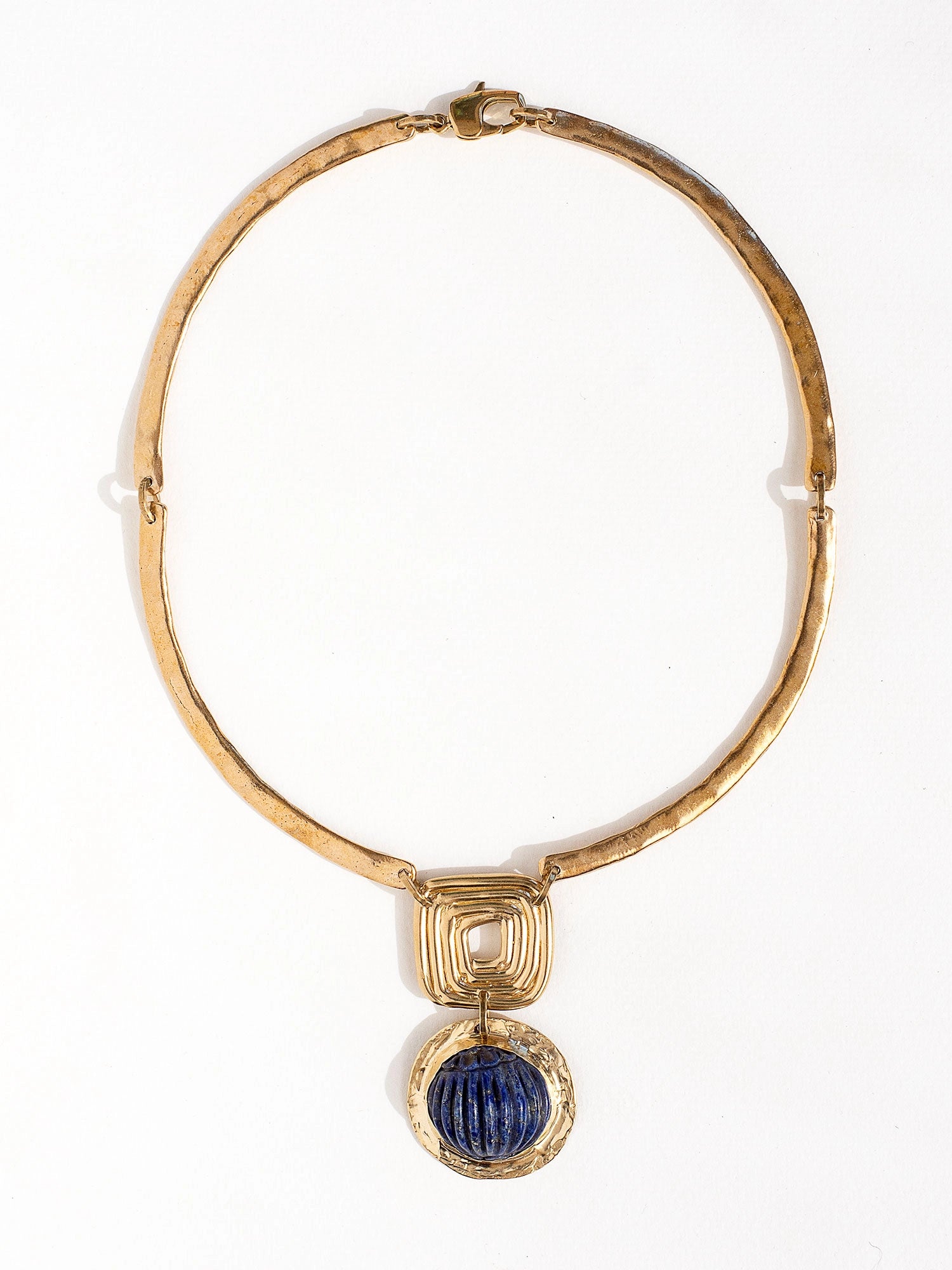 A solid brass collar necklace with a statement lapis lazuli pendant by Canadian jewelry designer Michelle Ross