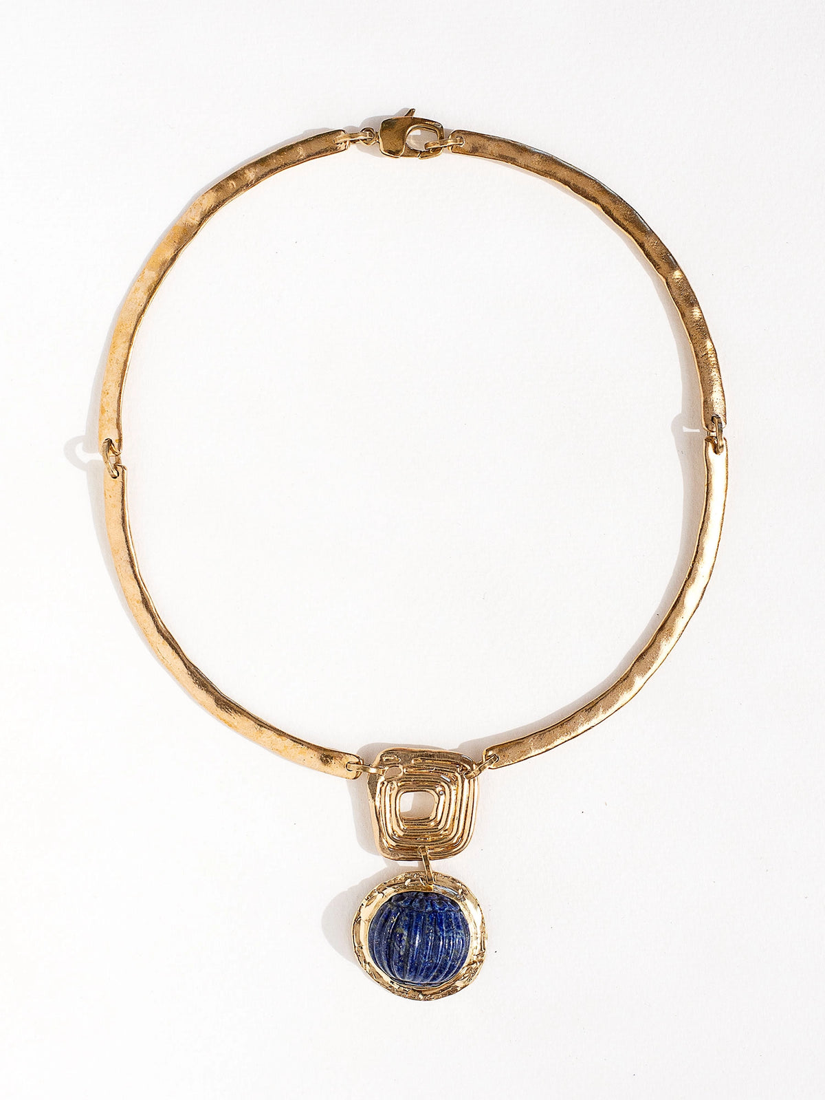 A solid brass collar necklace with a statement lapis lazuli pendant by Canadian jewelry designer Michelle Ross