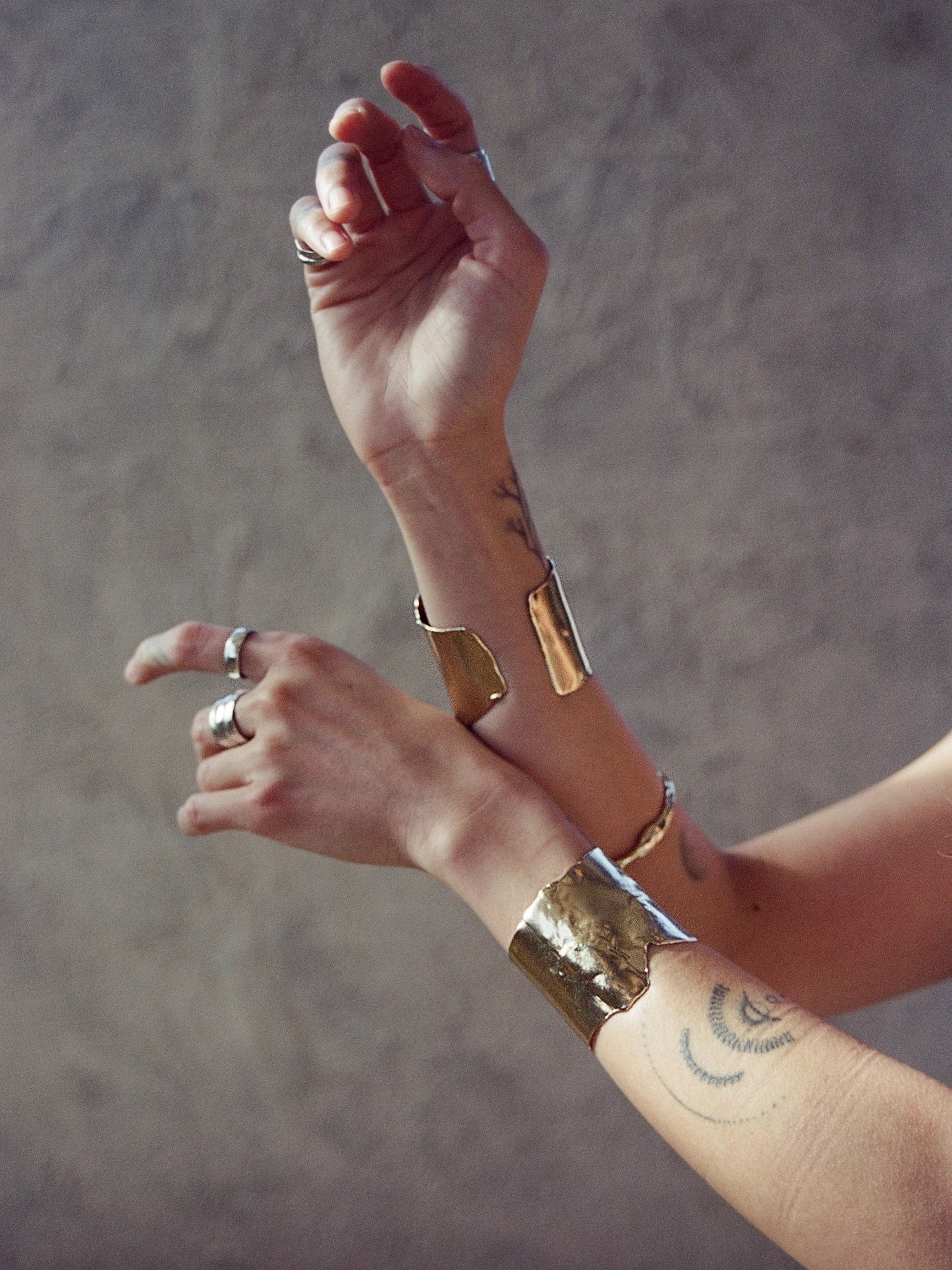 Close-up of a person's arm wearing 2 gold bangles