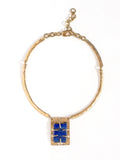 A solid brass collar necklace with a statement rectangular lapis lazuli pendant by Canadian jewelry designer Michelle Ross