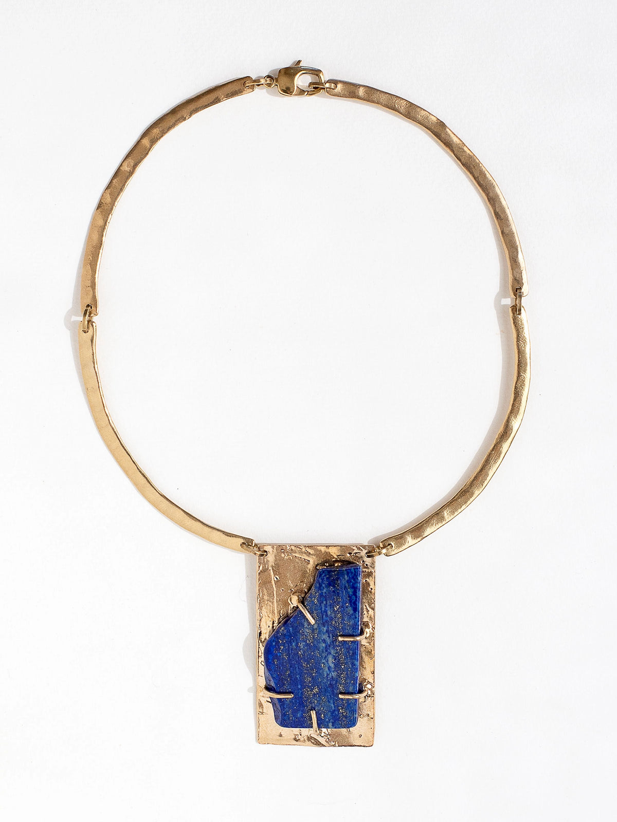 A solid brass collar necklace with a statement rectangular lapis lazuli pendant by Canadian jewelry designer Michelle Ross