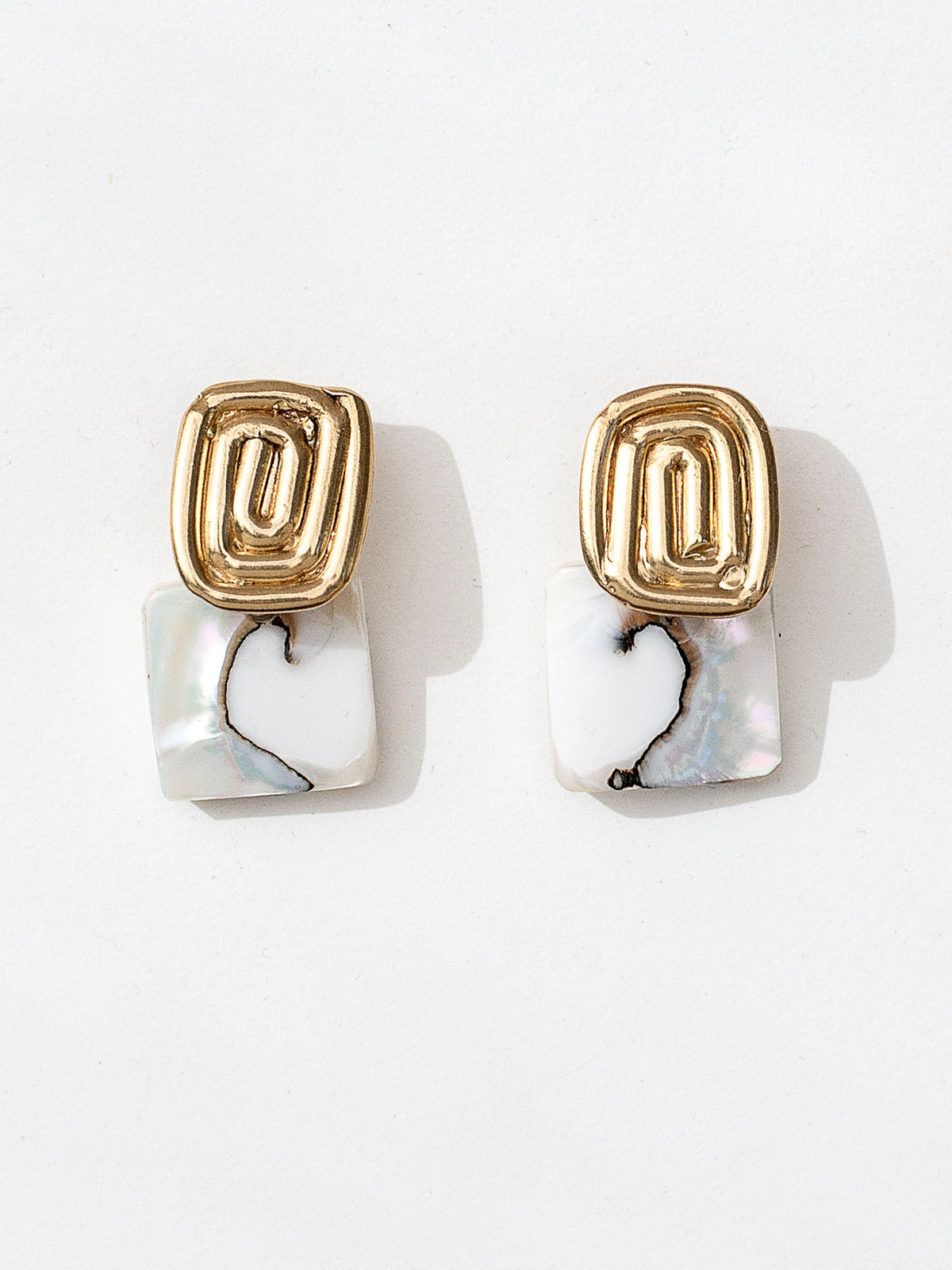A pair of brass spiral design earrings with square shell drops by Canadian jewelry designer Michelle Ross 
