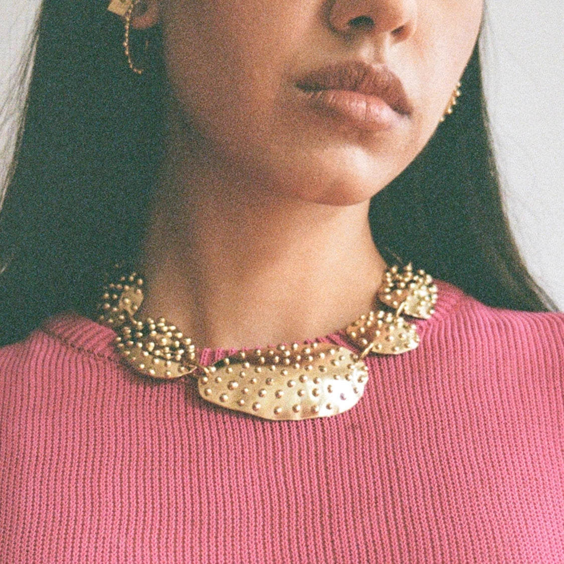 A woman wears a brass statement necklace handmade by Canadian jewellery designer Michelle Ross from Toronto