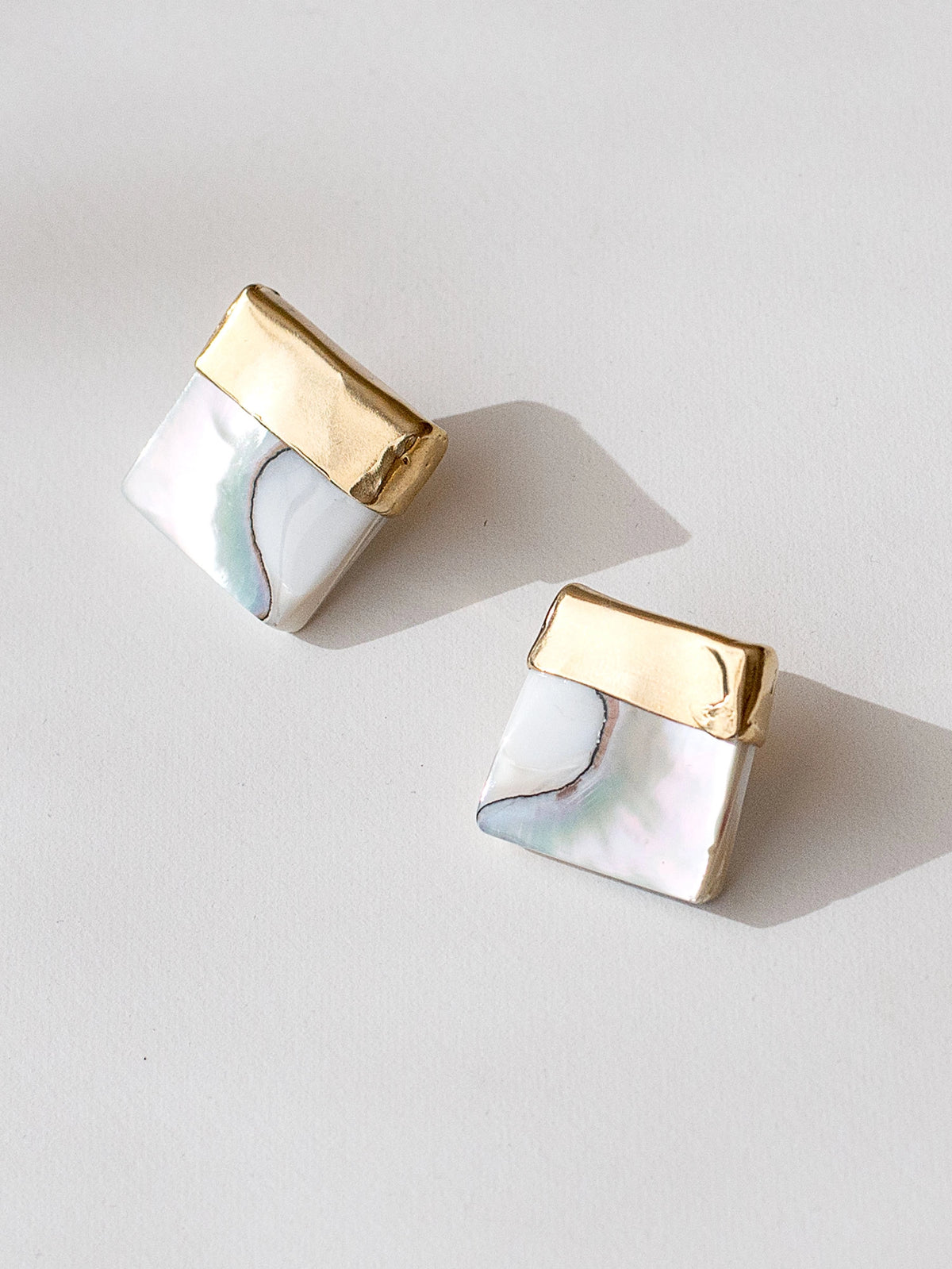 A pair of square shell mother of pearl and brass statement earrings by contemporary designer Michelle Ross