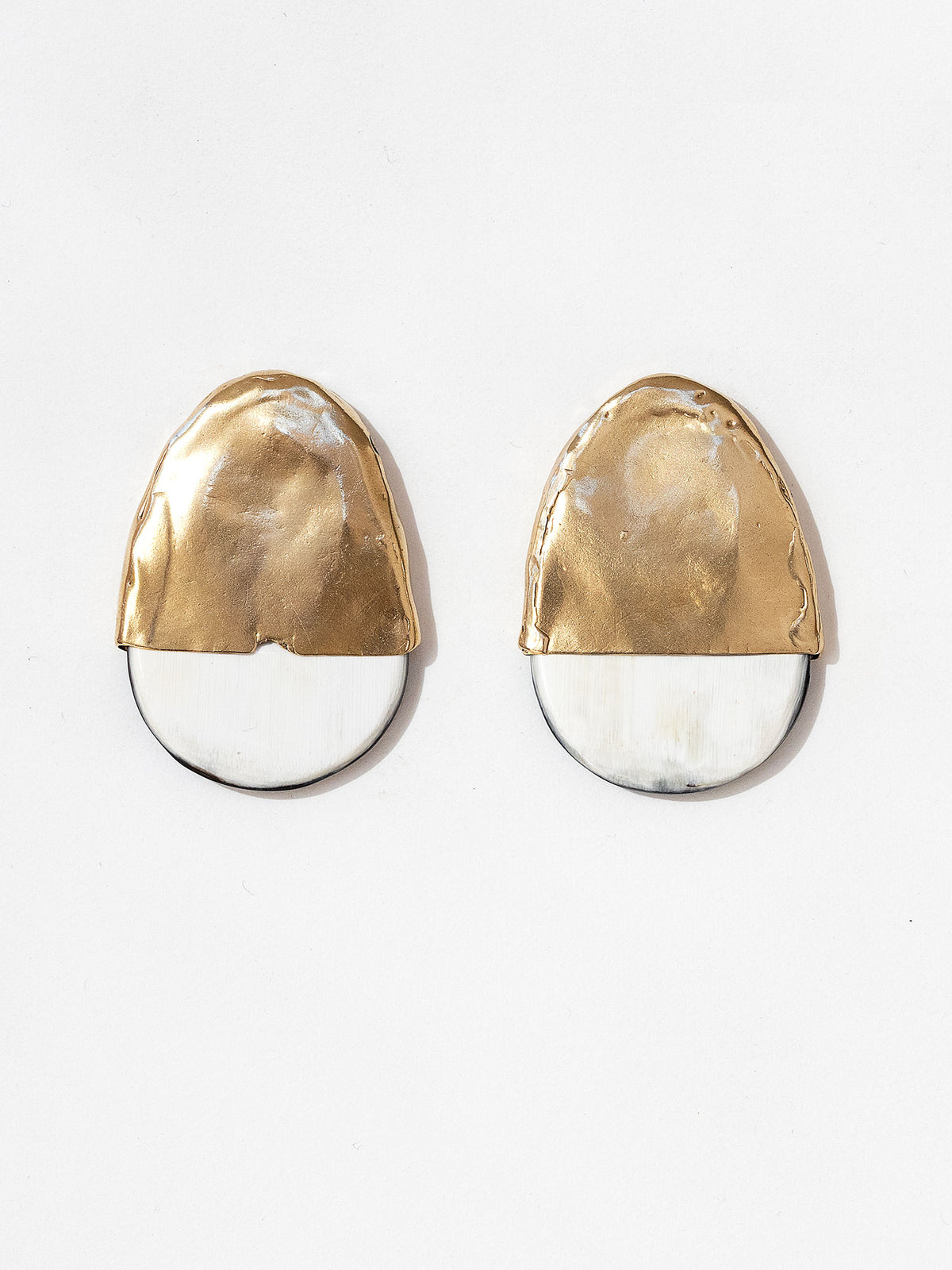 Pair of statement stud earrings with brass tops and blonde buffalo horn bases in a rounded shape by Michelle Ross
