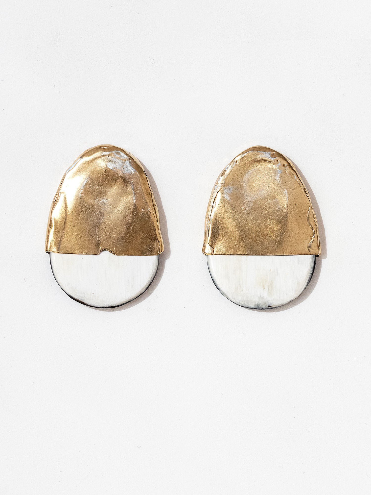 Pair of statement stud earrings with brass tops and blonde buffalo horn bases in a rounded shape by Michelle Ross