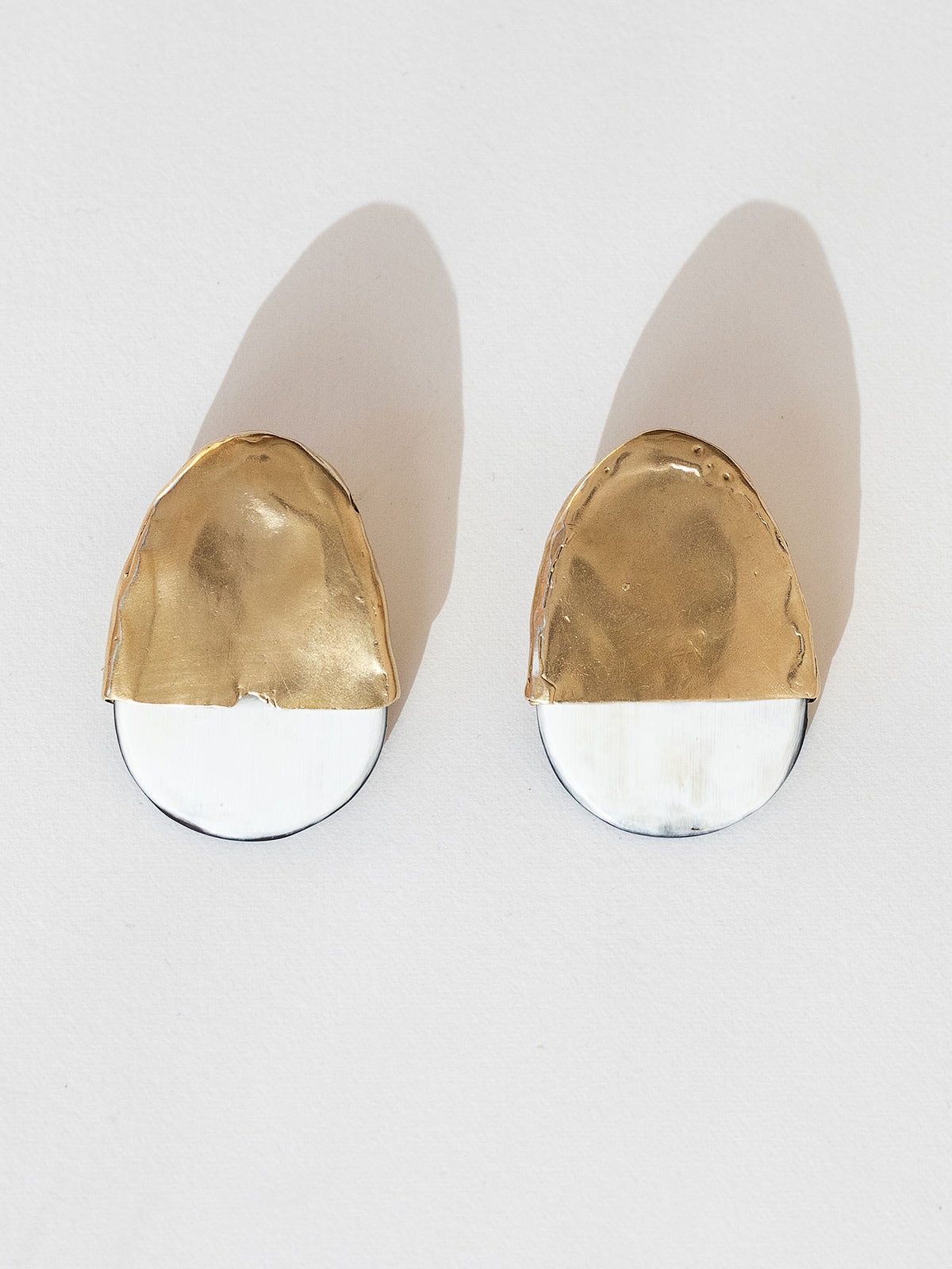 Pair of statement stud earrings with brass tops and blonde buffalo horn bases in a rounded shape by Michelle Ross