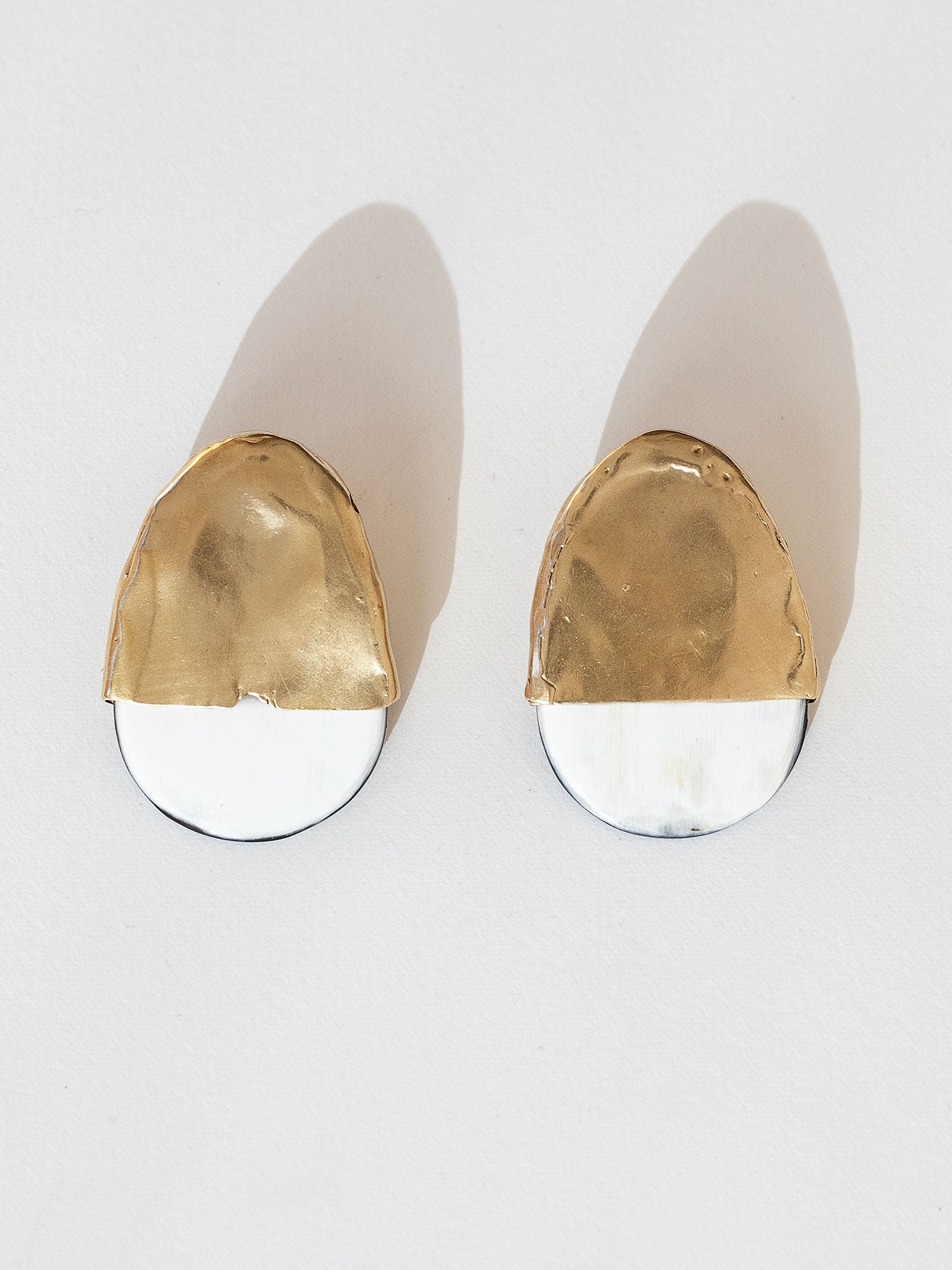 Pair of statement stud earrings with brass tops and blonde buffalo horn bases in a rounded shape by Michelle Ross