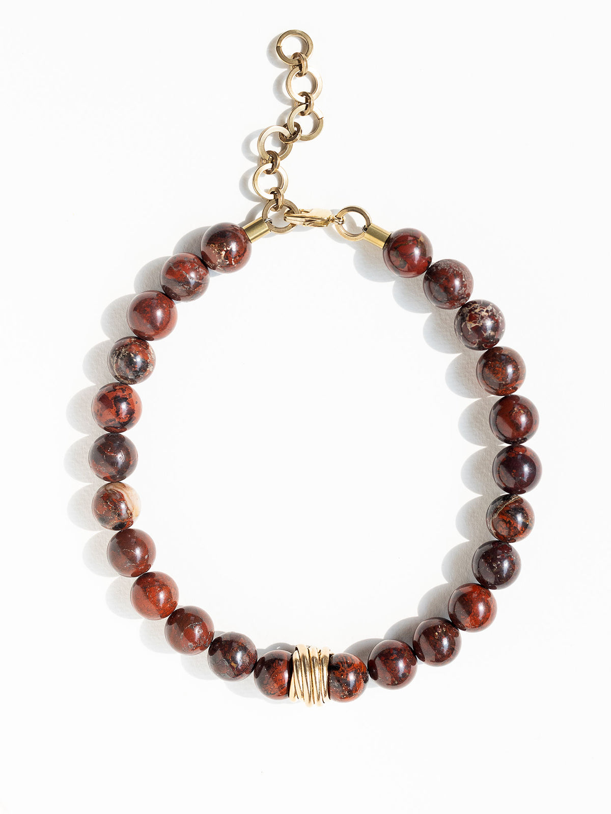 A beaded necklace made from red jasper stone beads with hand formed brass details by Canadian Jewelry Designer Michelle Ross