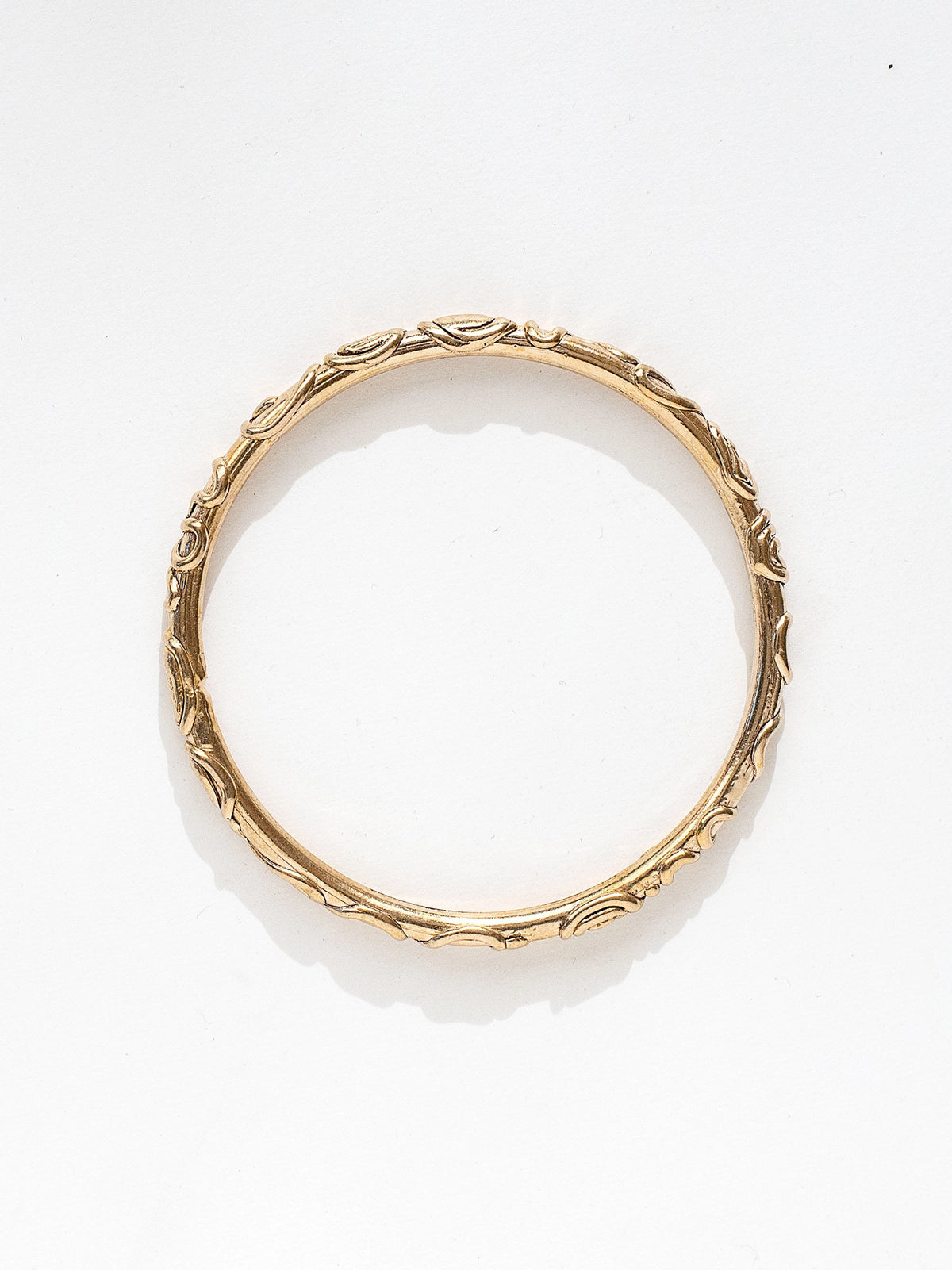 A solid brass bangle bracelet with spiral scrollwork details by Canadian jewelry designer Michelle Ross