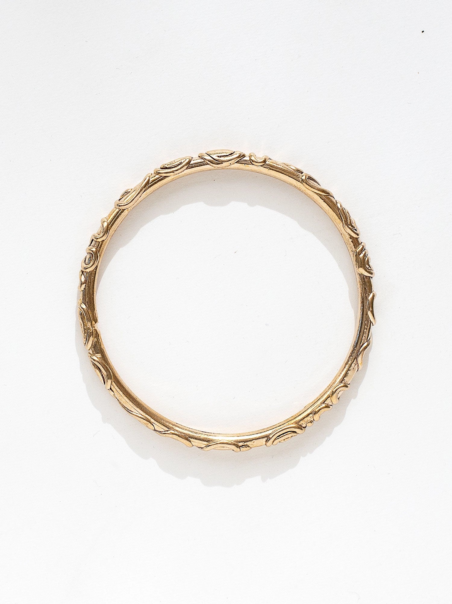 A solid brass bangle bracelet with spiral scrollwork details by Canadian jewelry designer Michelle Ross