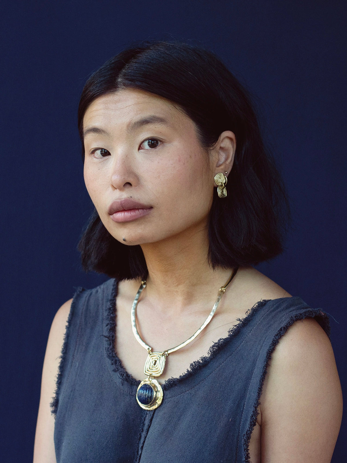 A woman wears a pair of brass spiral drop earrings by Toronto jewelry designer Michelle Ross