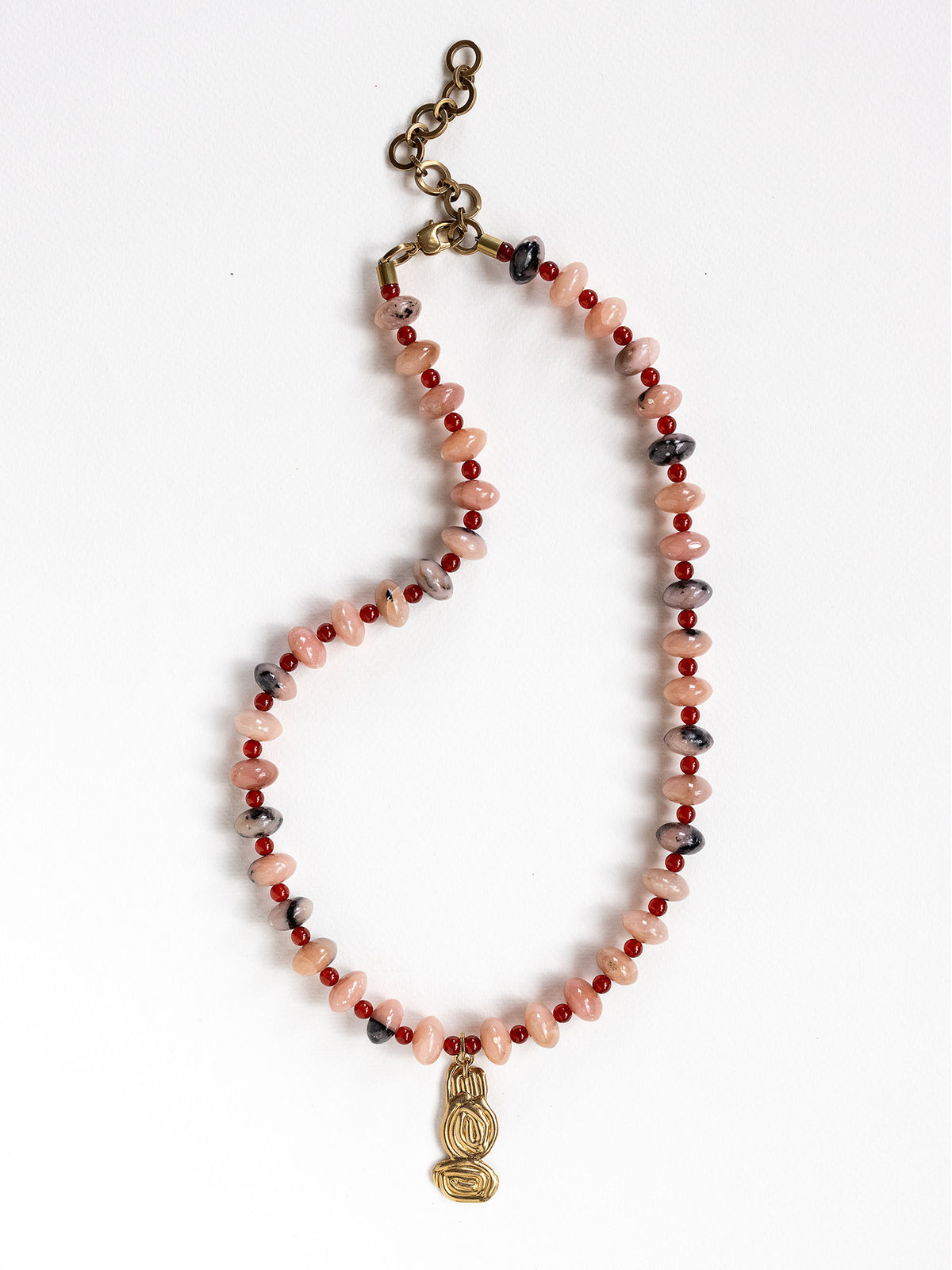 A beaded necklace featuring light pink stone with grey marbled beads, dark red beads, accented with a brass metal clasp by Canadian jewelry designer Michelle Ross