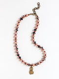 A beaded necklace featuring light pink stone with grey marbled beads, dark red beads, accented with a brass metal clasp by Canadian jewelry designer Michelle Ross