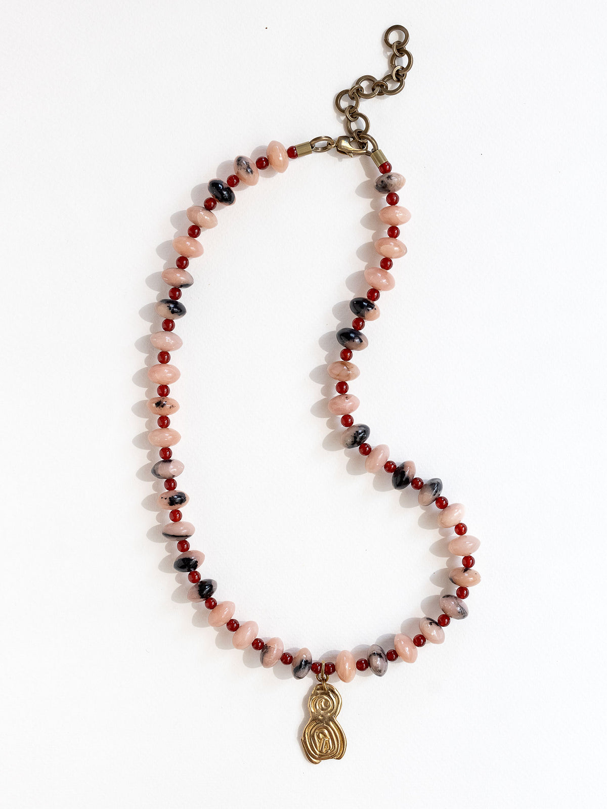A beaded necklace featuring light pink stone with grey marbled beads, dark red beads, accented with a brass metal clasp by Canadian jewelry designer Michelle Ross