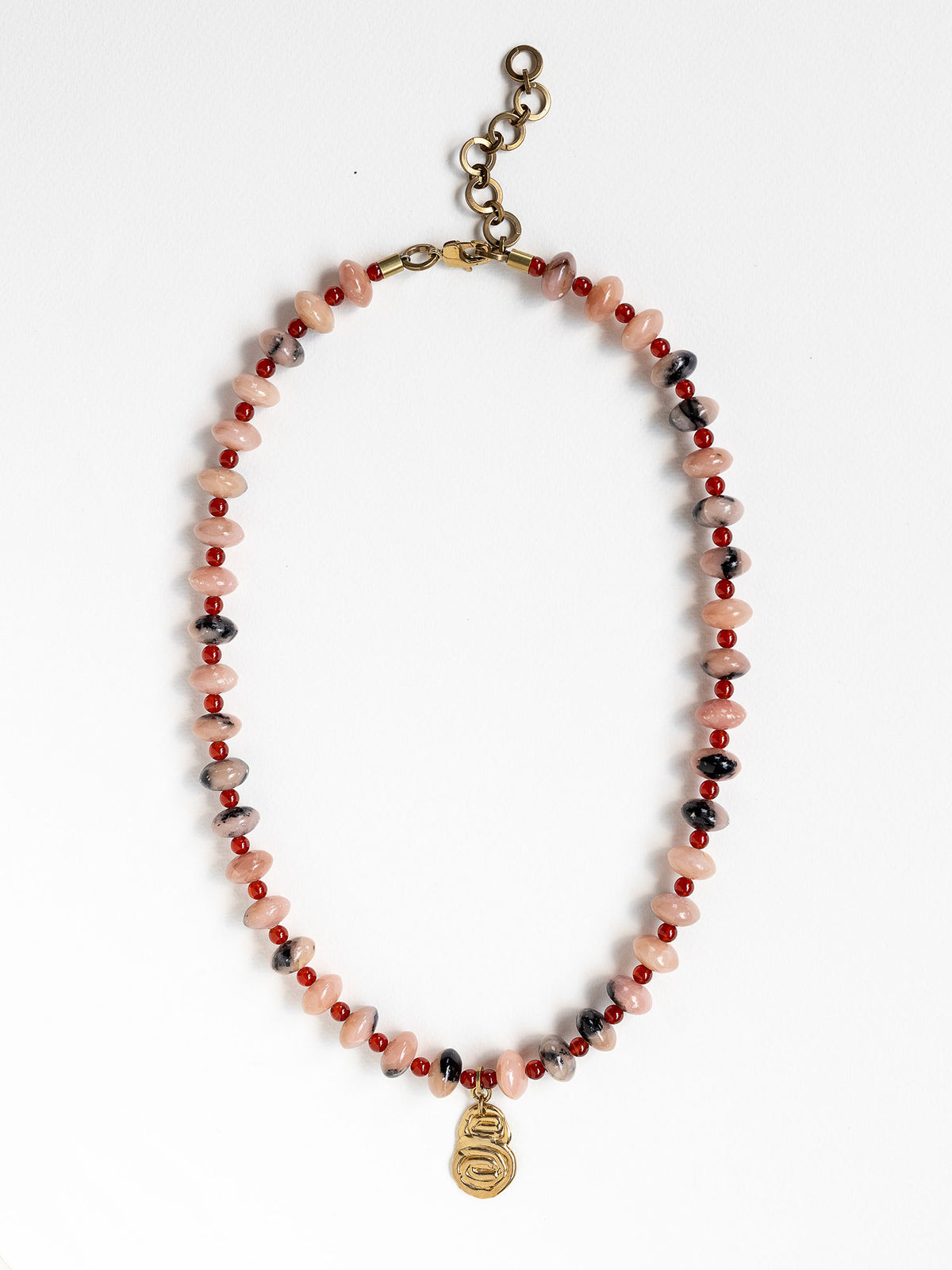 A beaded necklace featuring light pink stone with grey marbled beads, dark red beads, accented with a brass metal clasp by Canadian jewelry designer Michelle Ross