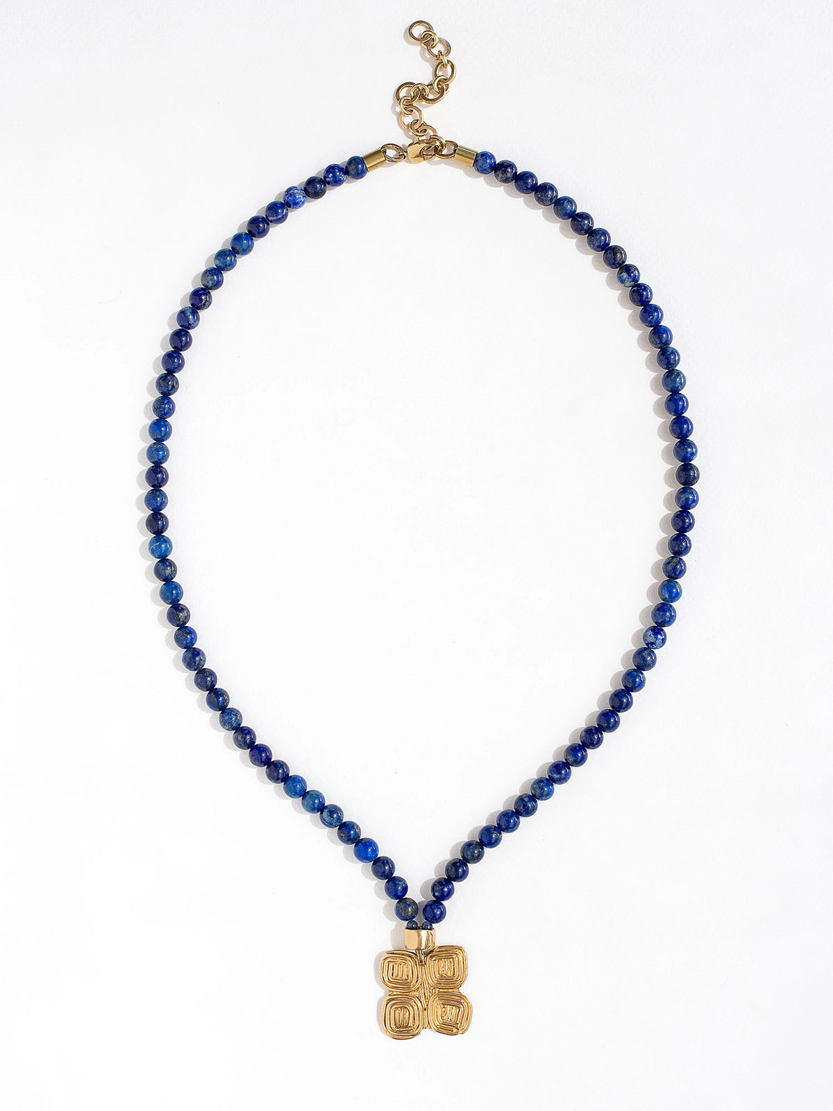 A lapis lazuli beaded necklace with a large statement brass spiral geometric pendant by Canadian jewellery designer Michelle Ross