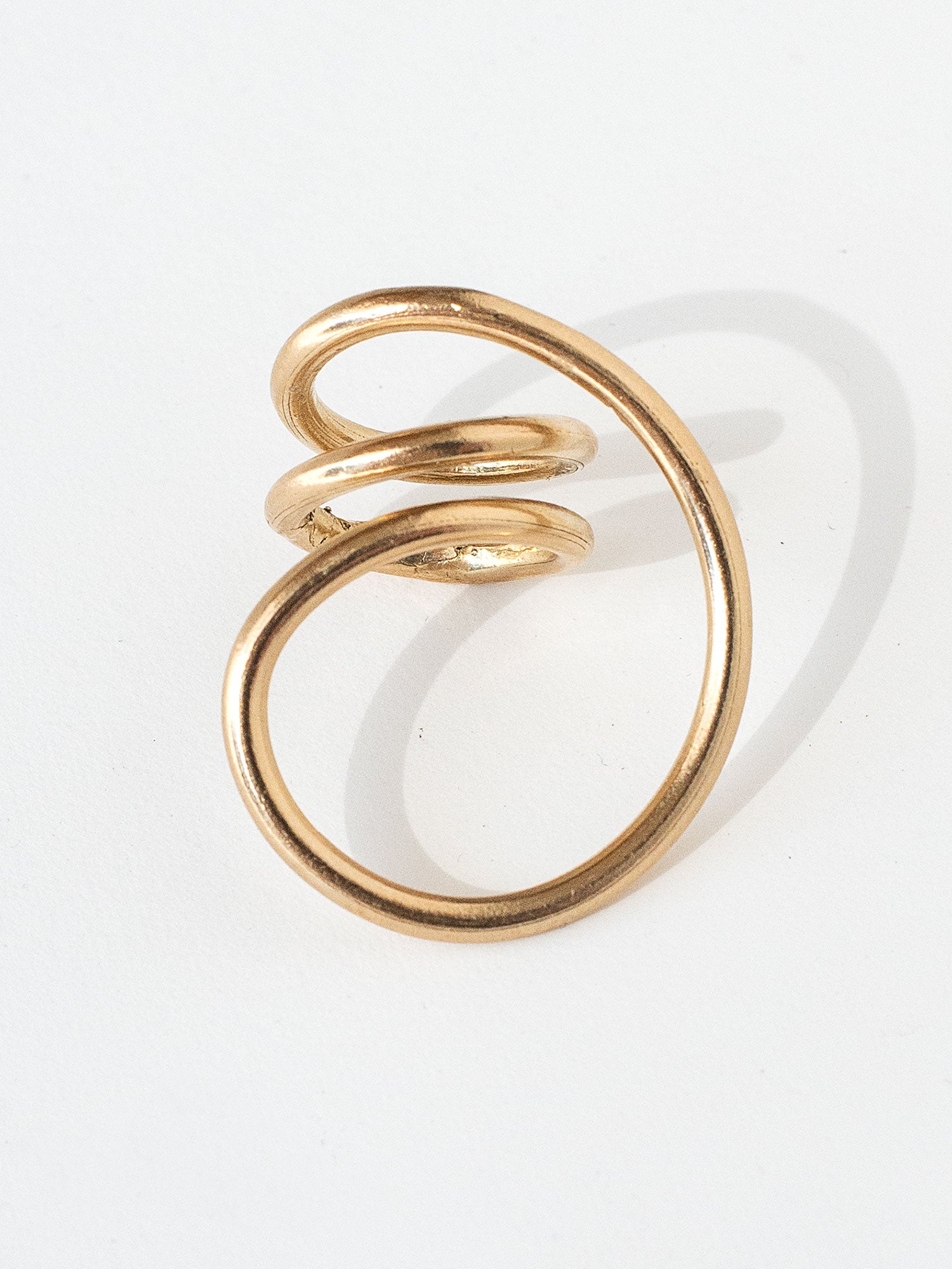 A handmade solid brass ring in an artistic twisting shape by Michele Ross in Toronto, Canada