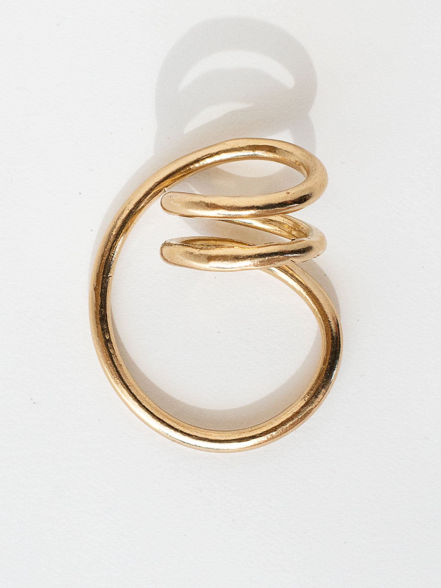 A handmade solid brass ring in an artistic twisting shape by Michele Ross in Toronto, Canada