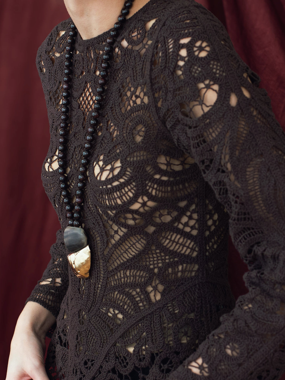 Necklace with garnet beads and a brass pendant by Canadian designer Michelle Ross