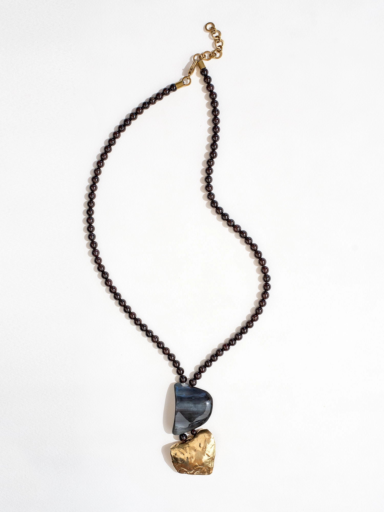 Necklace with garnet beads and a large horn and brass pendant  by Michelle Ross