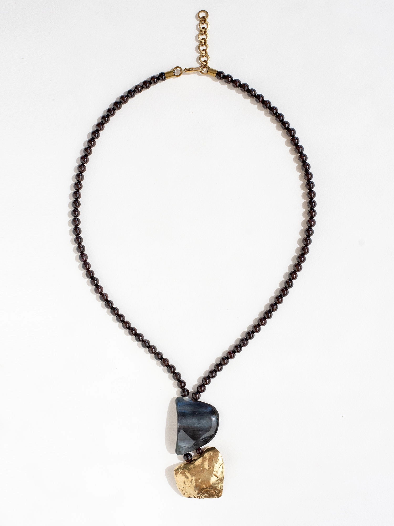 Necklace with garnet beads and a large horn and brass pendant  by Michelle Ross