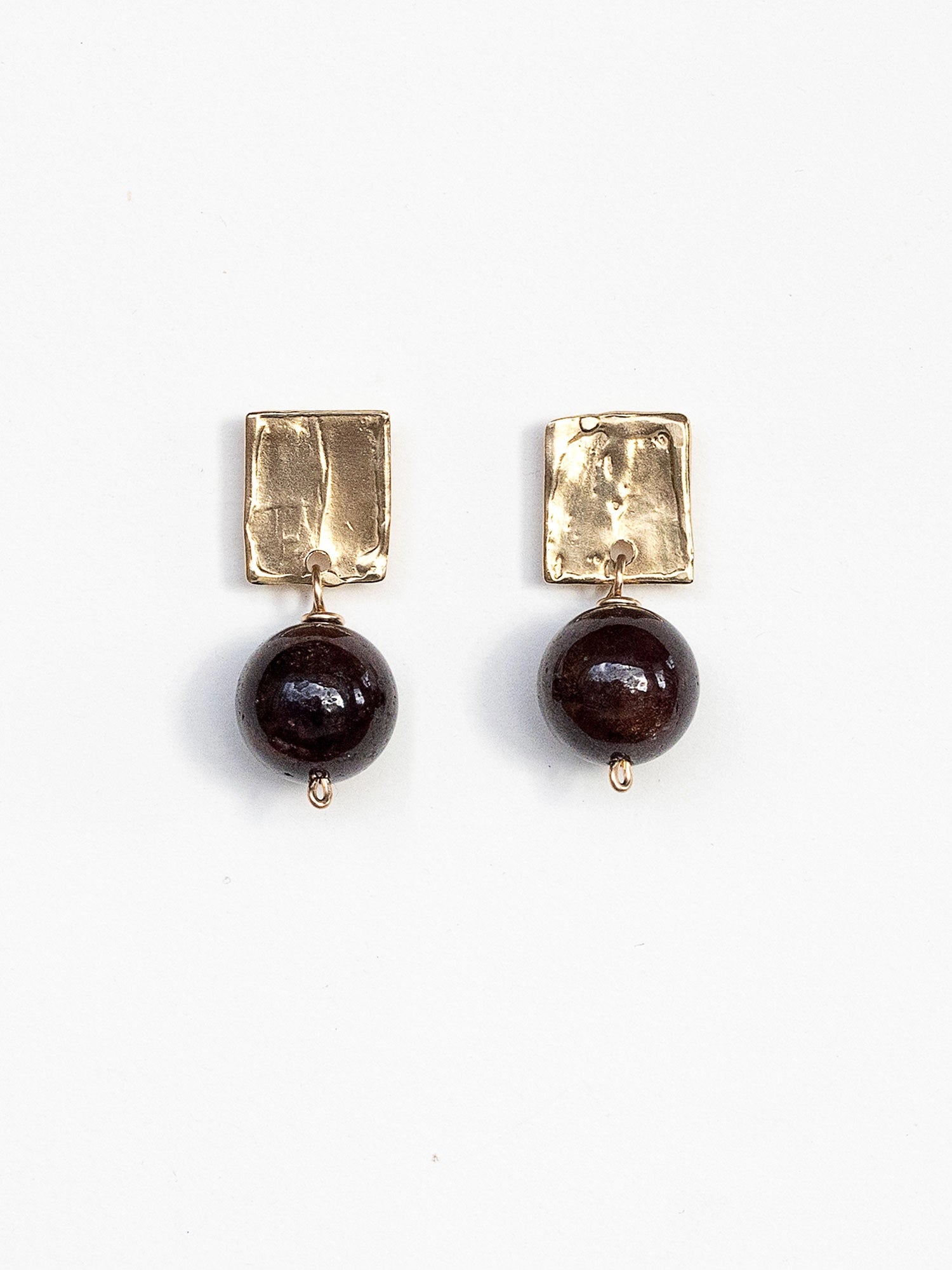 Pair of earrings with brass square tops and garnet beads by Michelle Ross