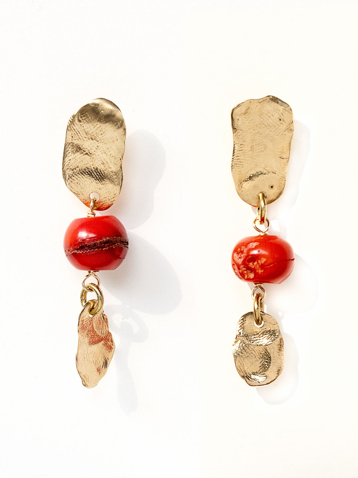A pair of handmade dangle brass earrings red coral and a small hand formed brass bead by Canadian jewelry designer Michelle Ross.