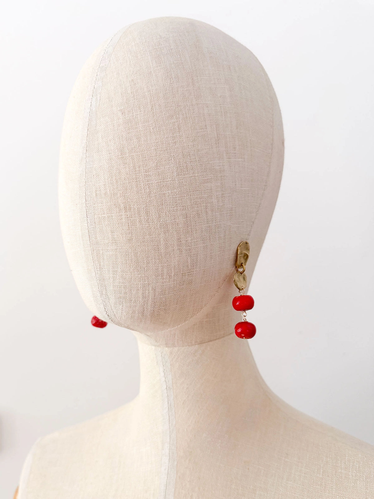 A pair of brass and red drop coral beaded  dangly earrings by Canadian jewelry designer Michelle Ross