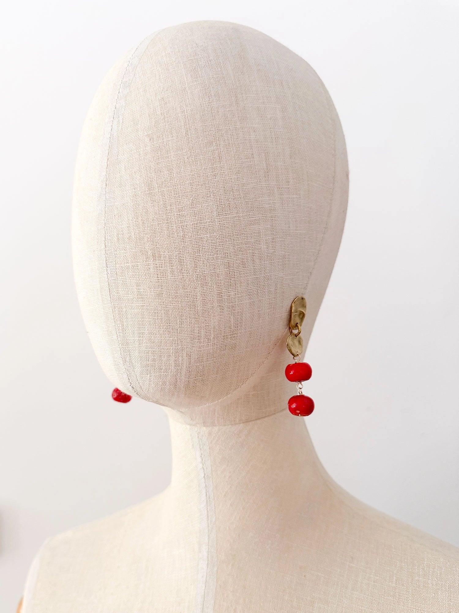 A pair of brass and red drop coral beaded  dangly earrings by Canadian jewelry designer Michelle Ross