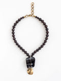 Necklace with garnet beads and a large black horn and brass pendant by Michelle Ross