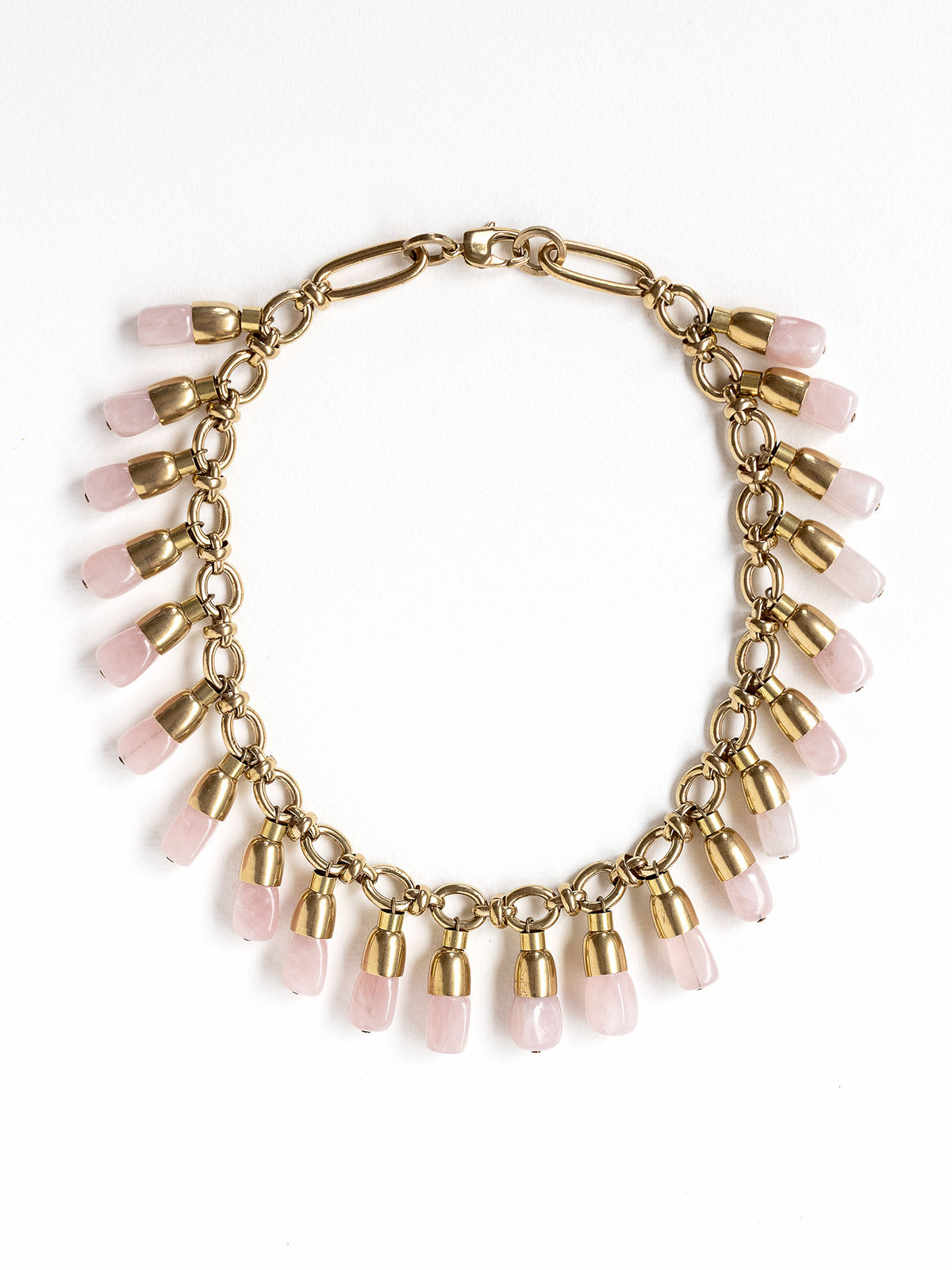 A statement collar necklace featuring a brass chain and links with dangling rose quartz beads by Canadian designer Michelle Ross