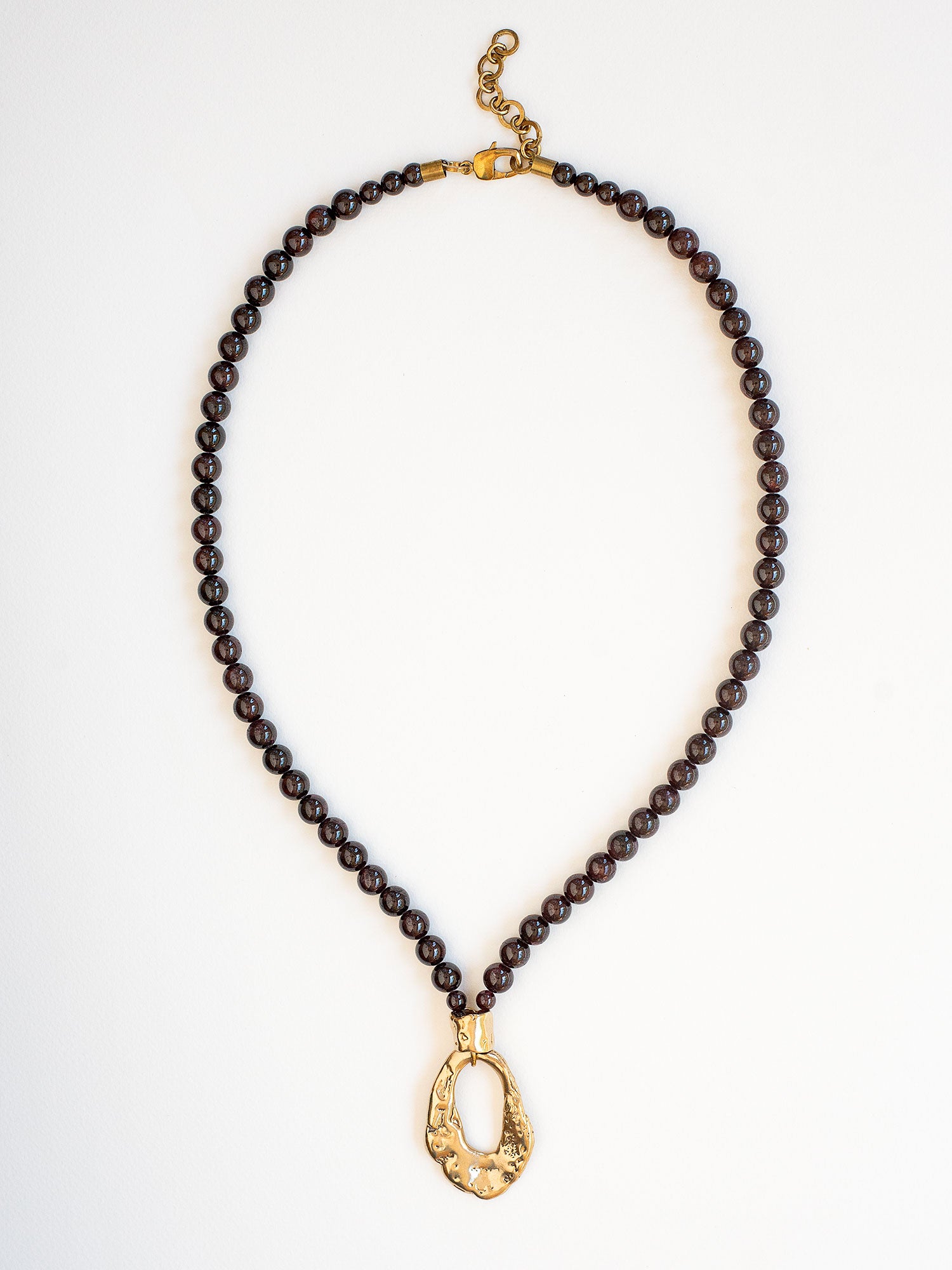 Necklace with garnet beads and brass pendant by Michelle Ross