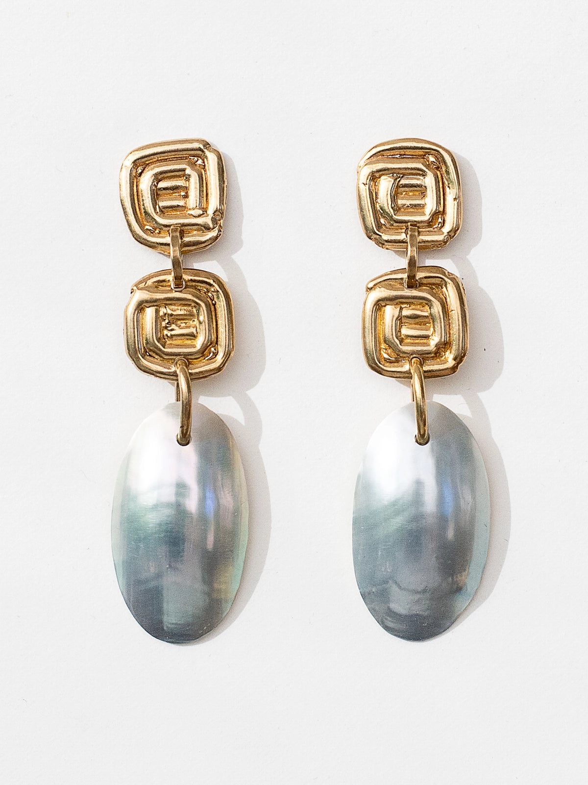 A pair of shell and brass dangly statement earrings by Canadian jewelry designer Michelle Ross