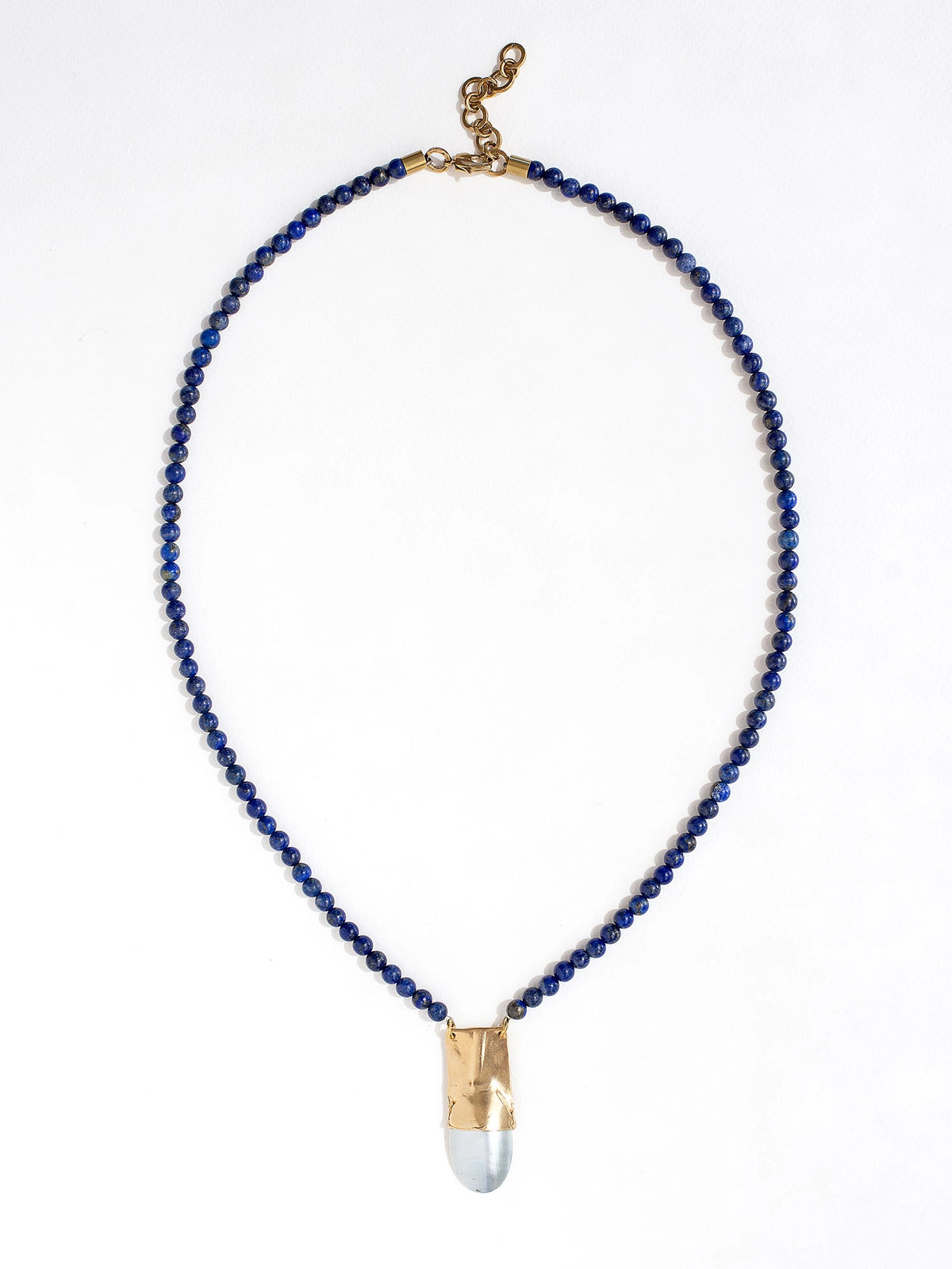 A lapis lazuli beaded necklace with a large statement mother of pearl and brass pendant by Canadian jewellery designer Michelle Ross