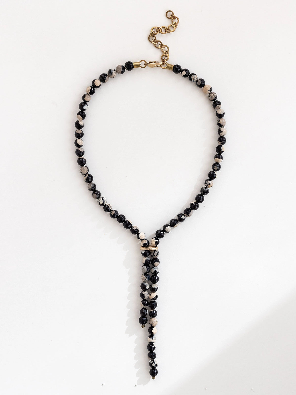 Lariat style necklace with black pink and grey marbled agate beads and a brass clasp by Michelle Ross