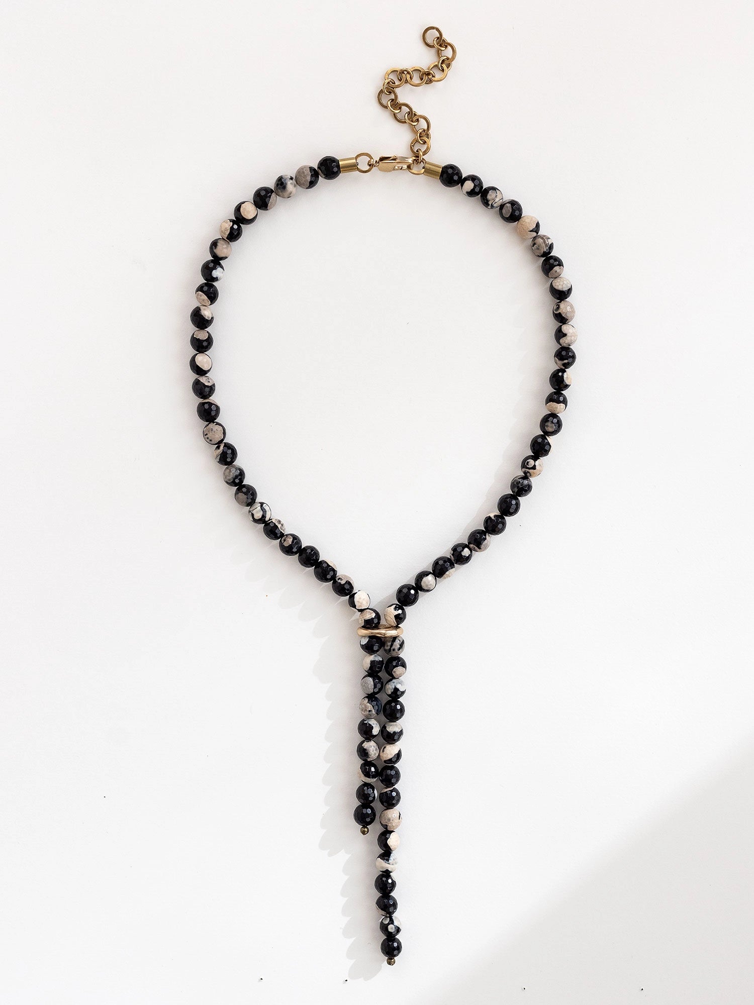 Lariat style necklace with black pink and grey marbled agate beads and a brass clasp by Michelle Ross