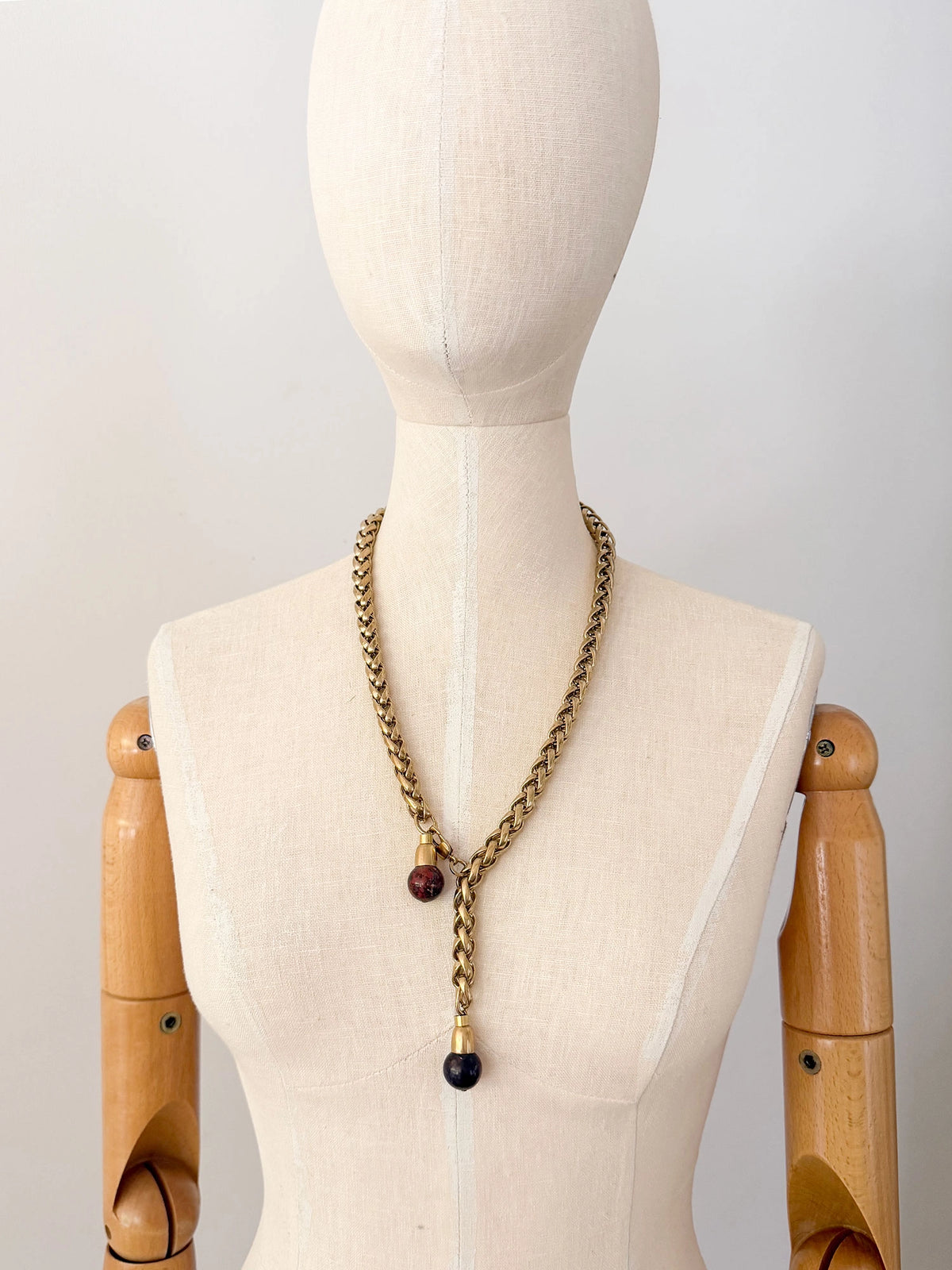 A brass chain lariat necklace with two red jasper bead tassels by Canadian jewelry designer Michelle Ross