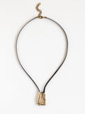 Long black leather necklace with a brass sculptural pendant by Michelle Ross