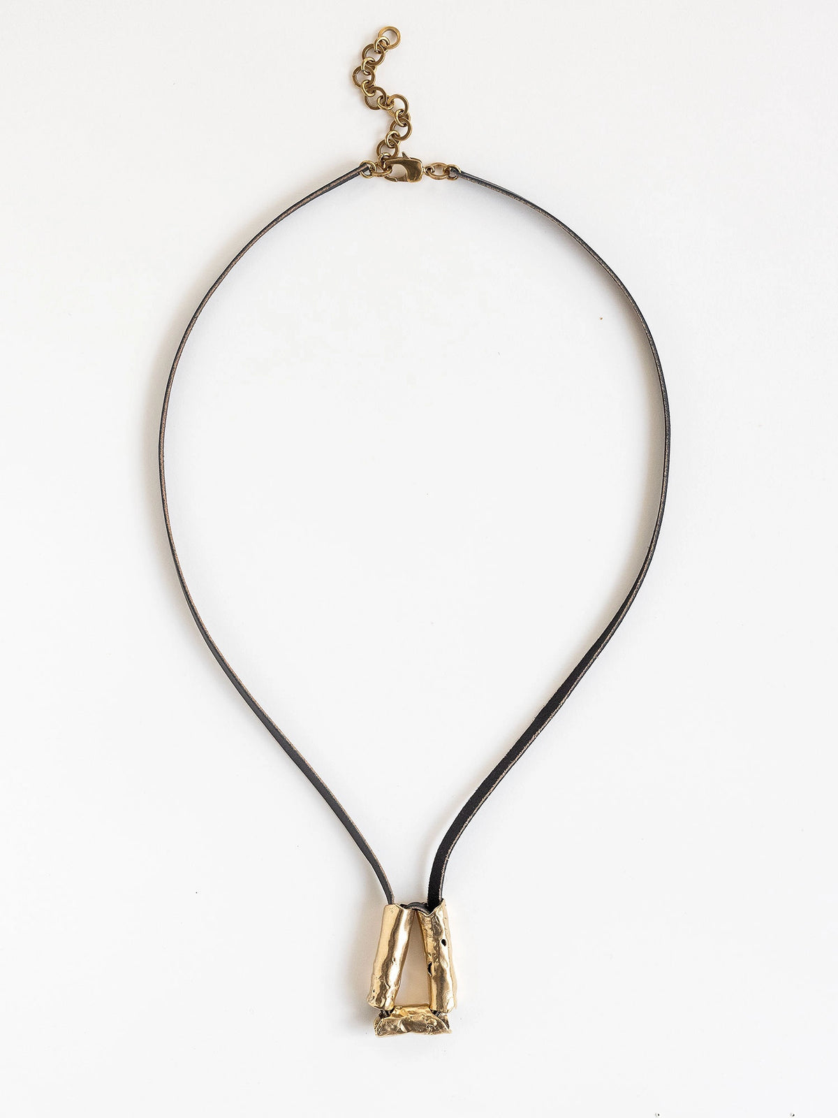 Long black leather necklace with a brass sculptural pendant by Michelle Ross
